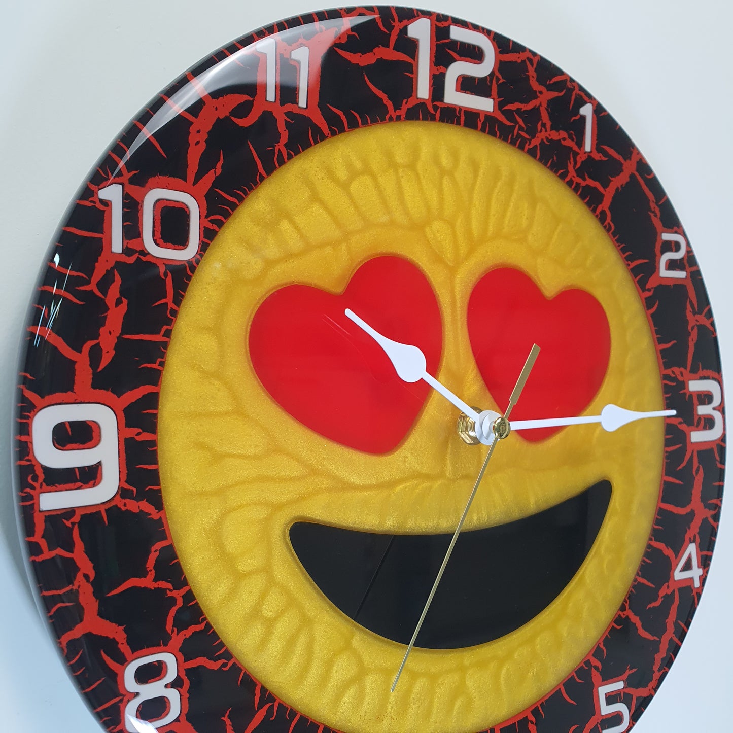 Detail shot showing glossy epoxy texture and heart-shaped eyes on Cuore Rosso clock