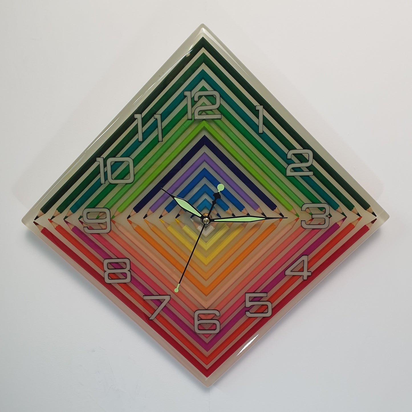 Front view of rainbow geometric epoxy wall clock with glow-in-the-dark hands