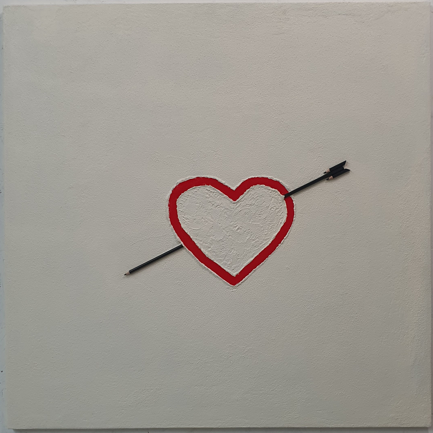 La Matita nel Cuore conceptual artwork – red heart pierced by pencil arrow on neutral background, front view