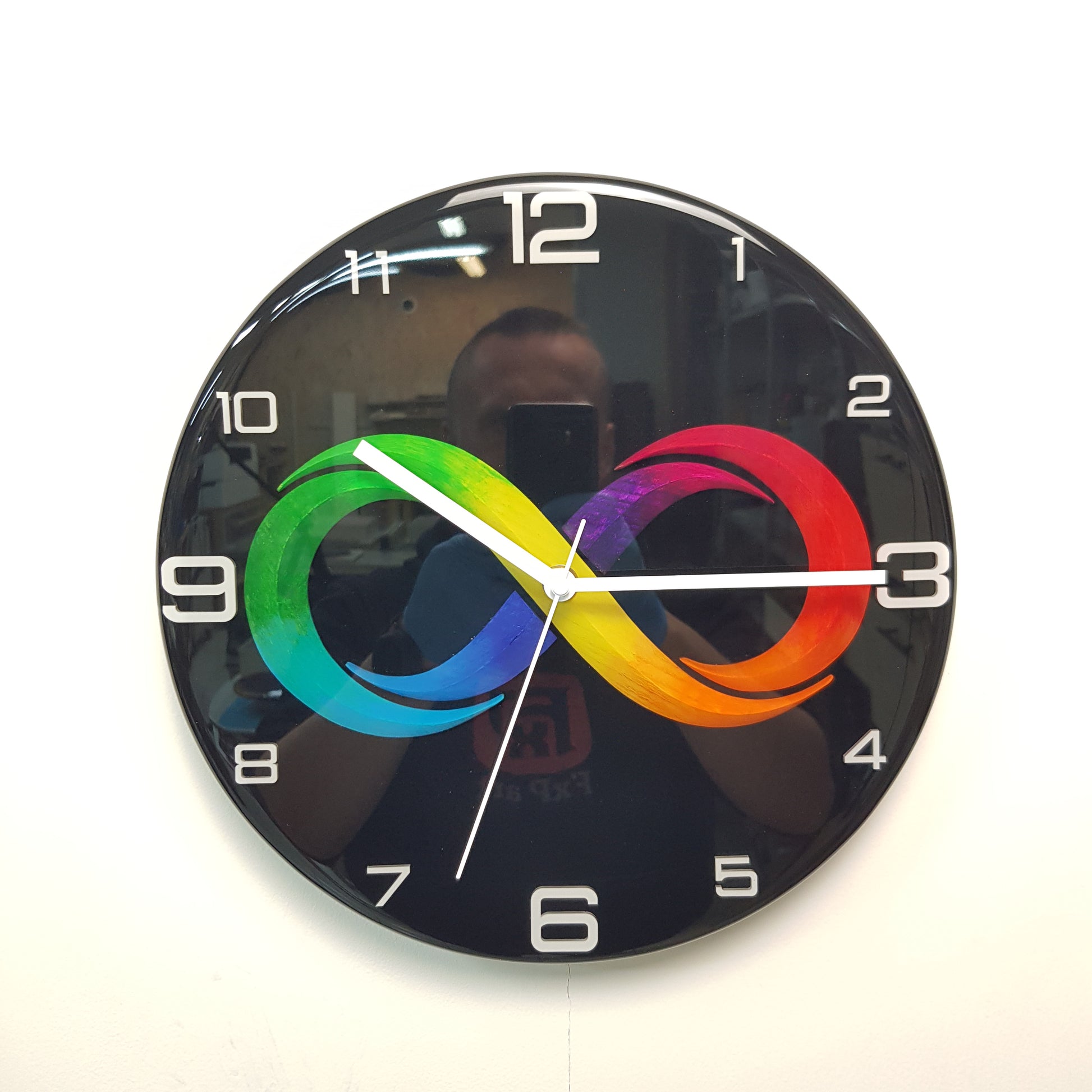 Front view of the Black Infinity epoxy resin wall clock with a colorful infinity symbol on a glossy black background