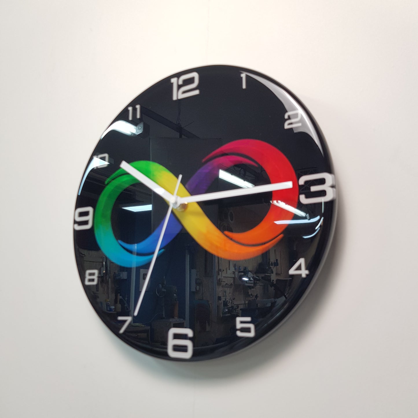 Angled perspective showing the mirror-like black finish and contemporary infinity artwork