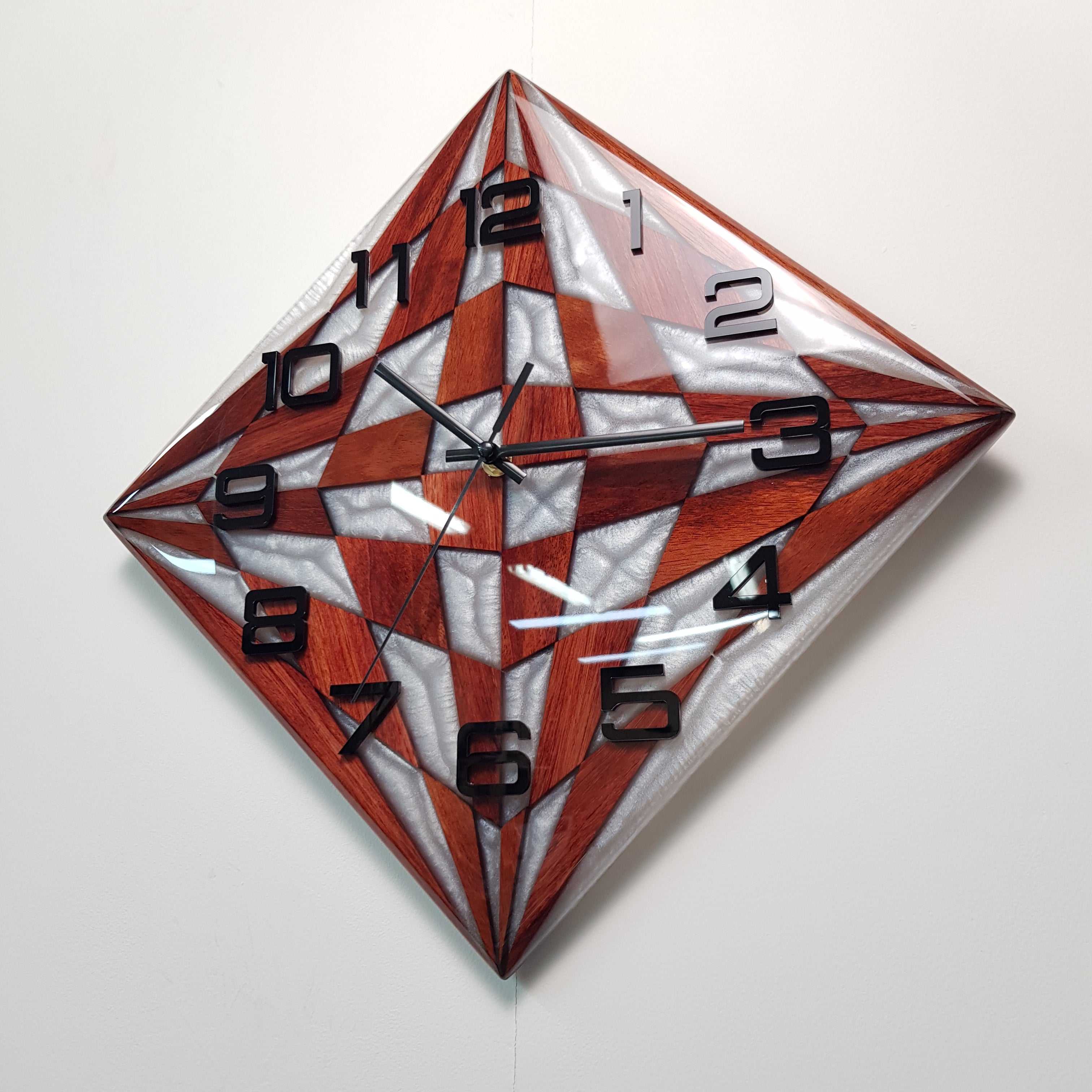 Angled close-up highlighting the pearly resin glow and modern black hands