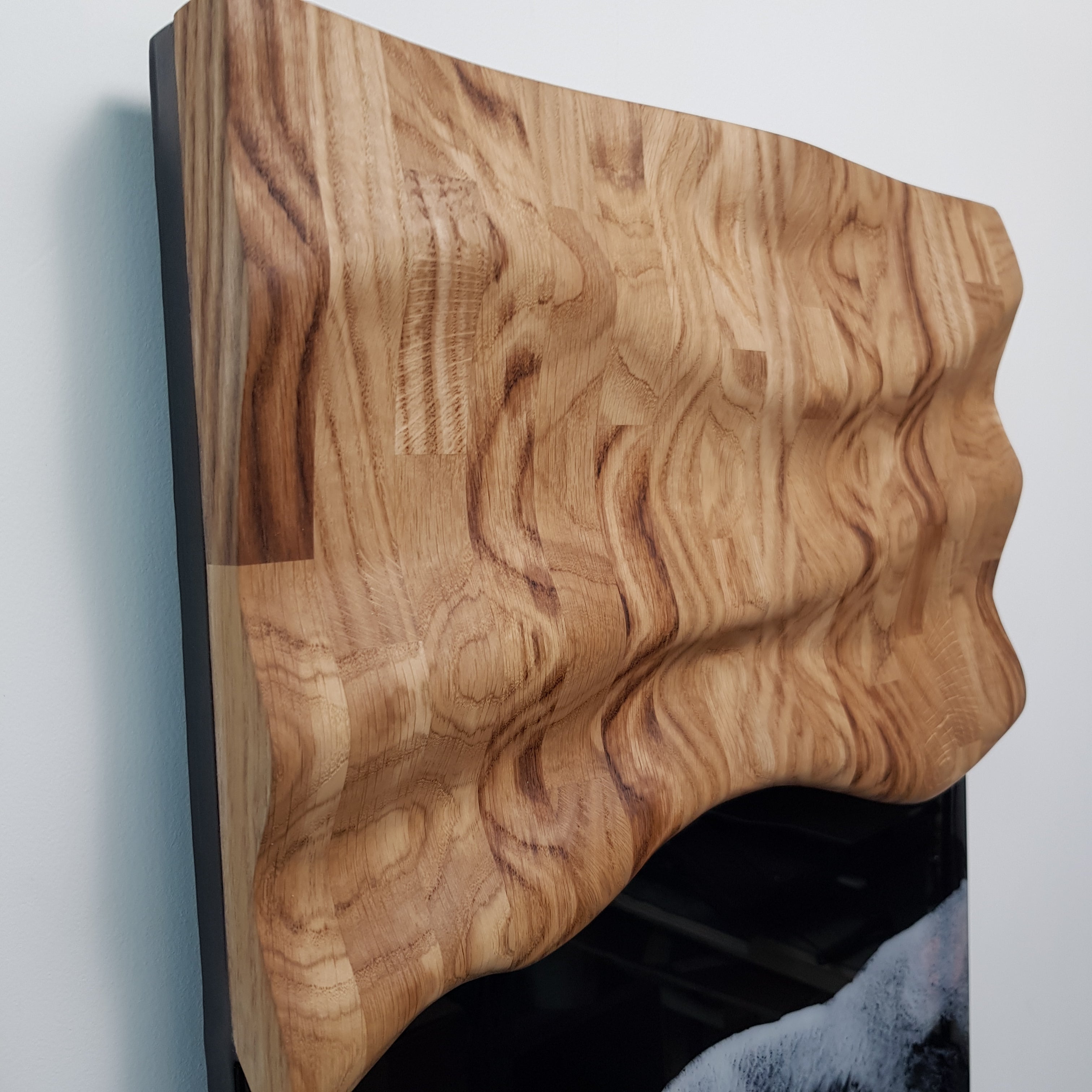 Modern oak wood and resin wall sculpture with white waves on black background