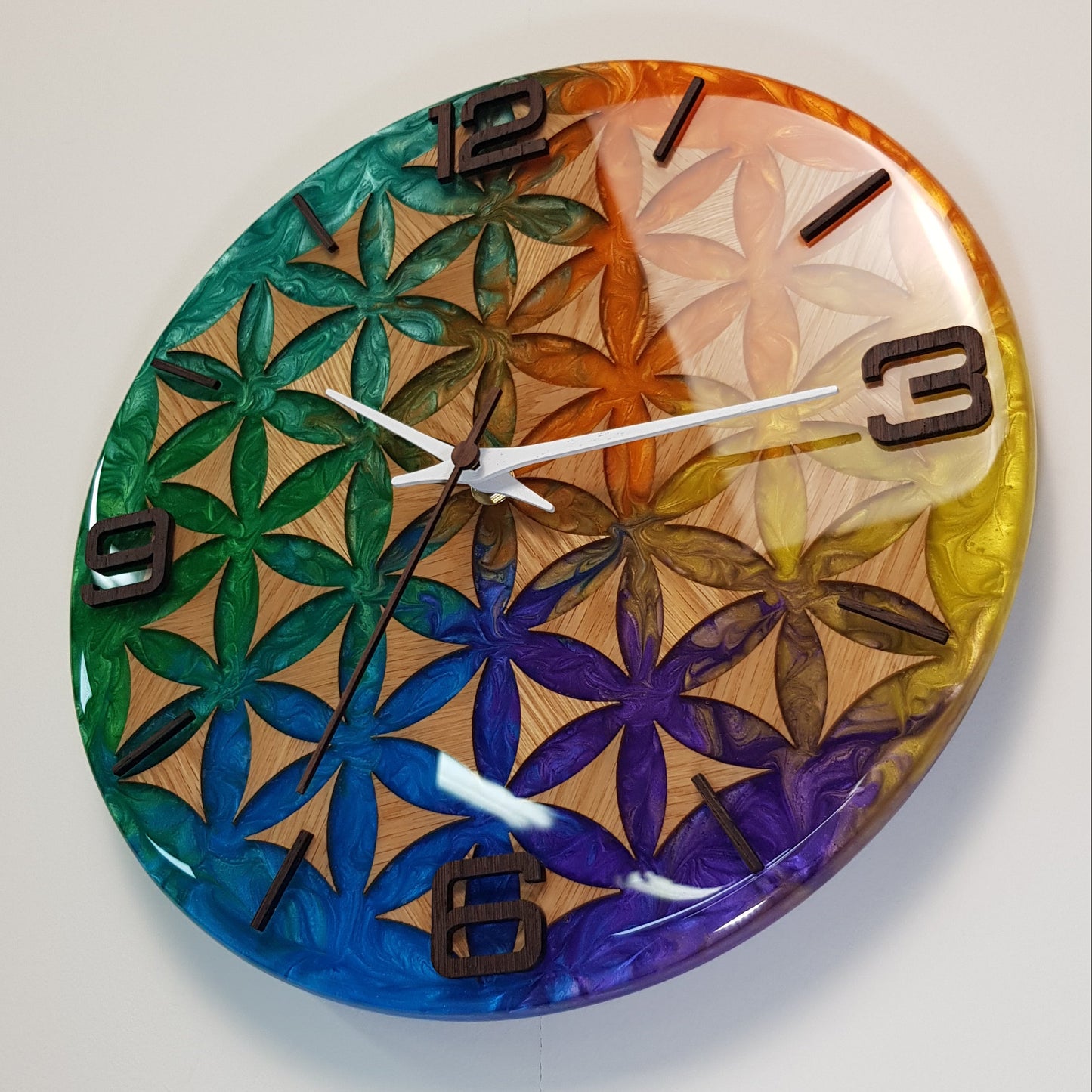 Life Essence wall clock seen from the left side – smooth glossy resin surface and depth of color reflections.