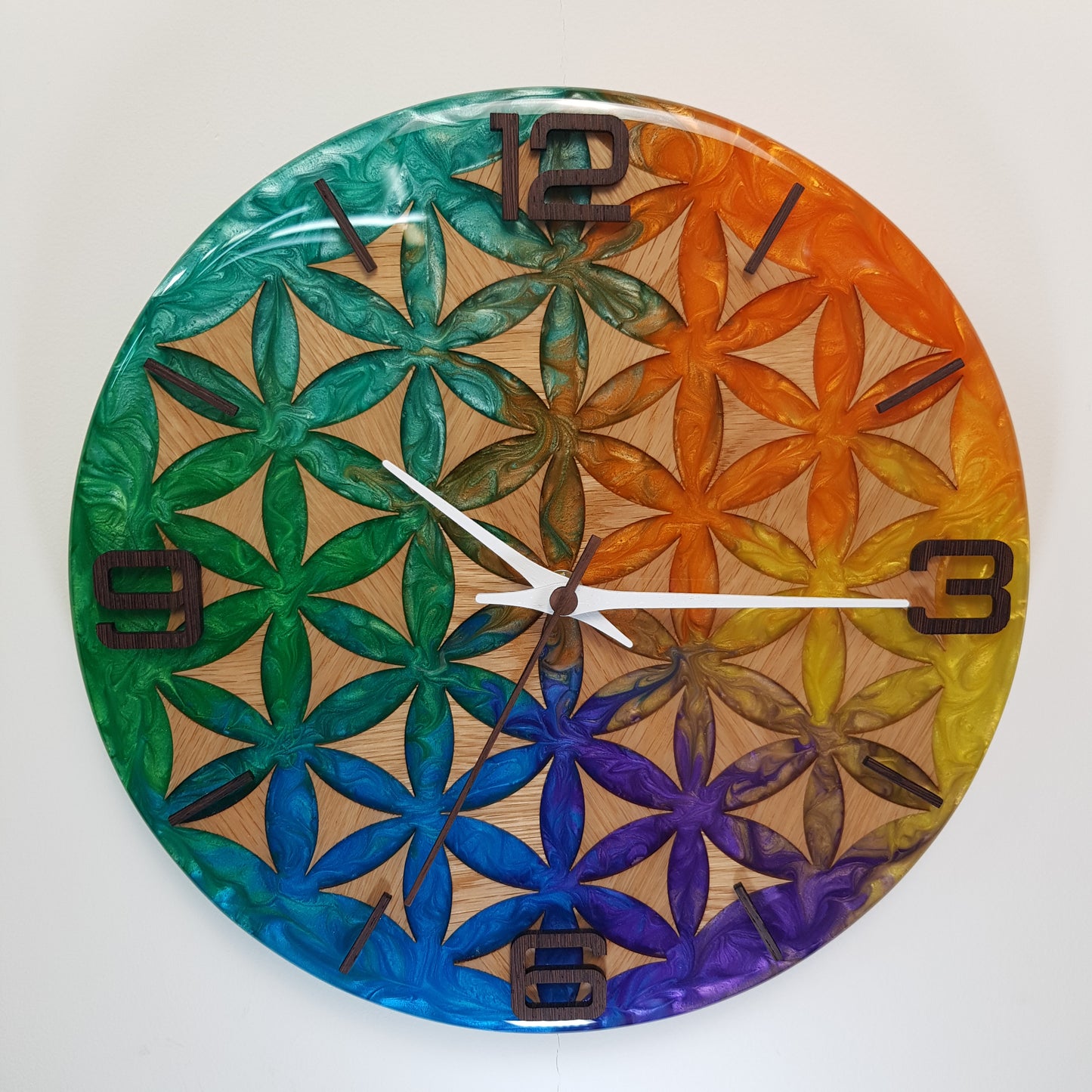 Wood Line – Life Essence wall clock – full front view showing the Flower of Life pattern in oak wood and colorful epoxy resin.