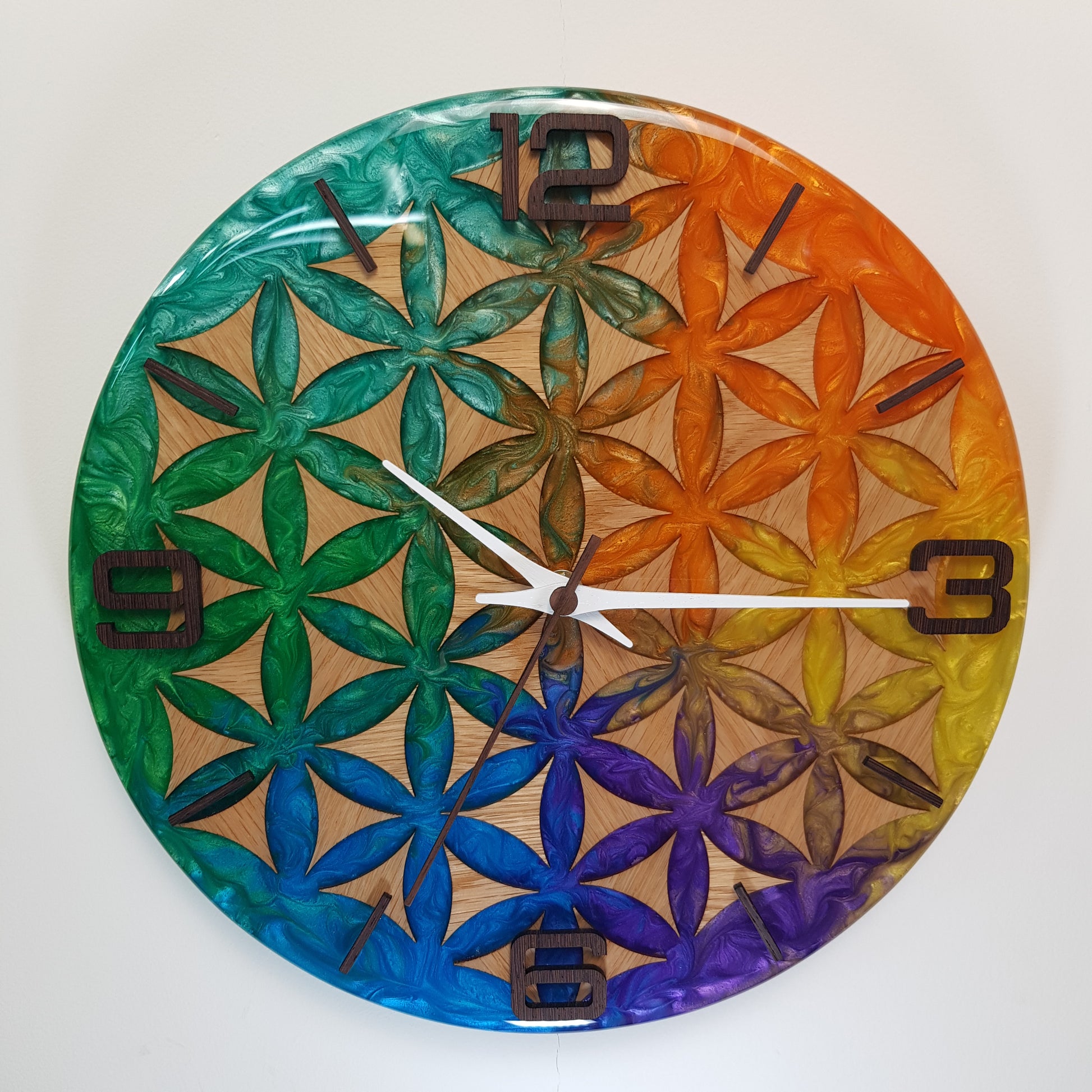 Wood Line – Life Essence wall clock – full front view showing the Flower of Life pattern in oak wood and colorful epoxy resin.