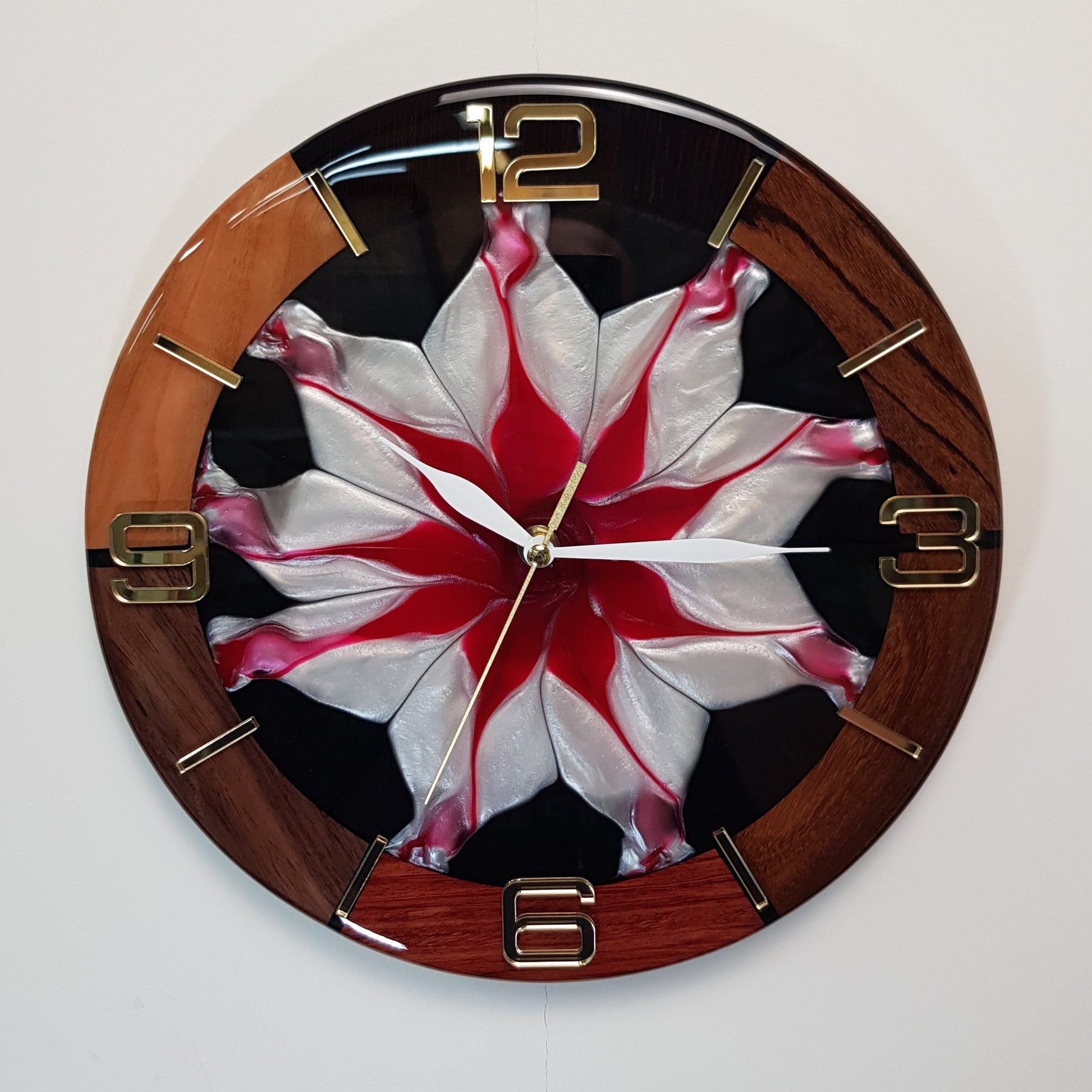 Front view of the “Frozen Flame” wall clock showing the red-and-white resin center and gold plexiglass markers
