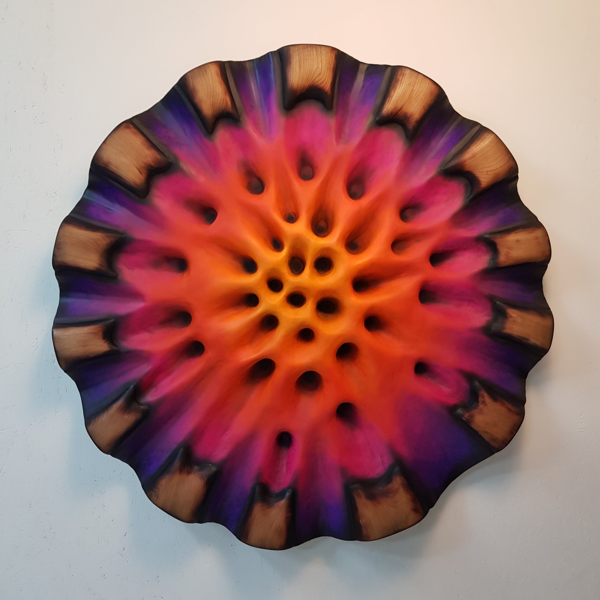 Front view of Fiamma Interna circular wall sculpture with glowing pink and purple core