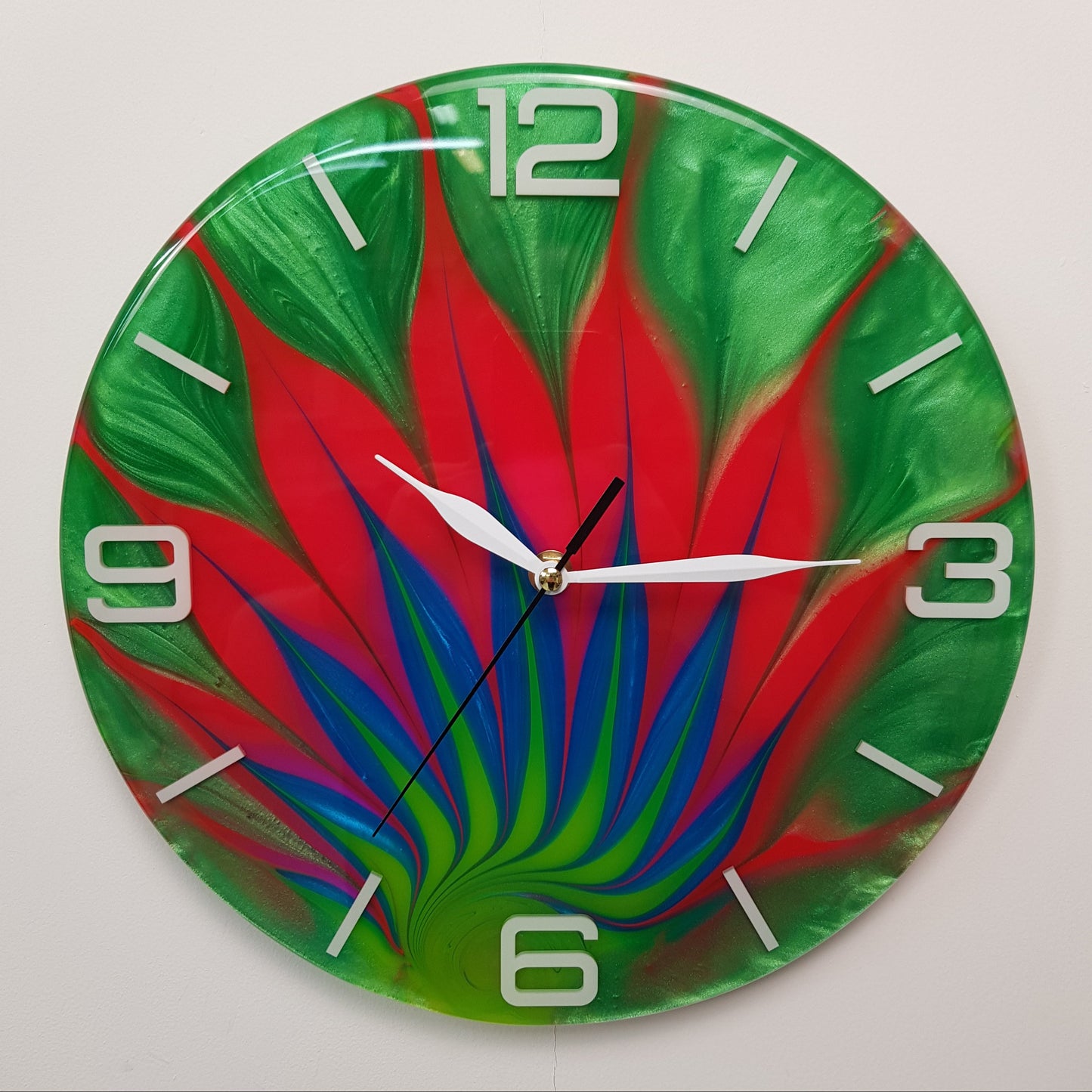 Front view of the “Wild Leaf” epoxy wall clock showing the full vibrant red, green, and blue pattern.