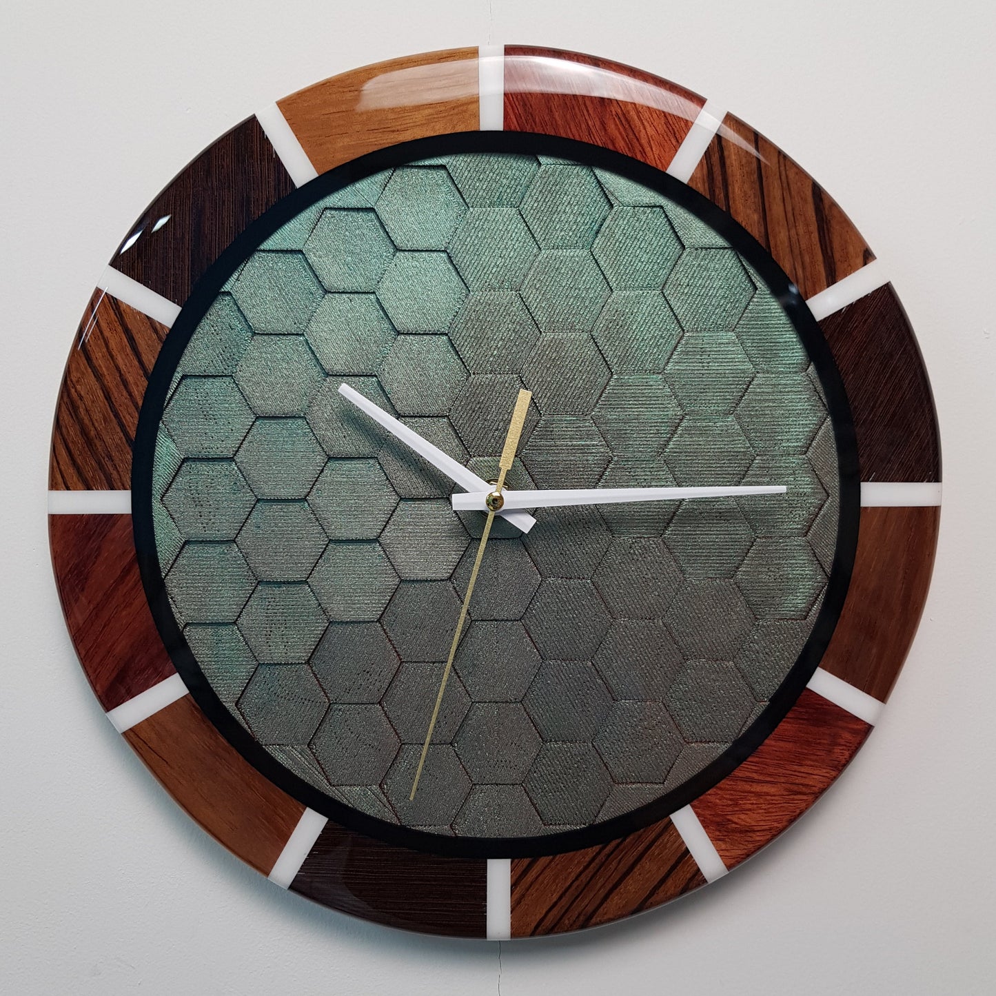 Front view of the “Chromatic Hive” clock showing the full honeycomb center and wooden ring.