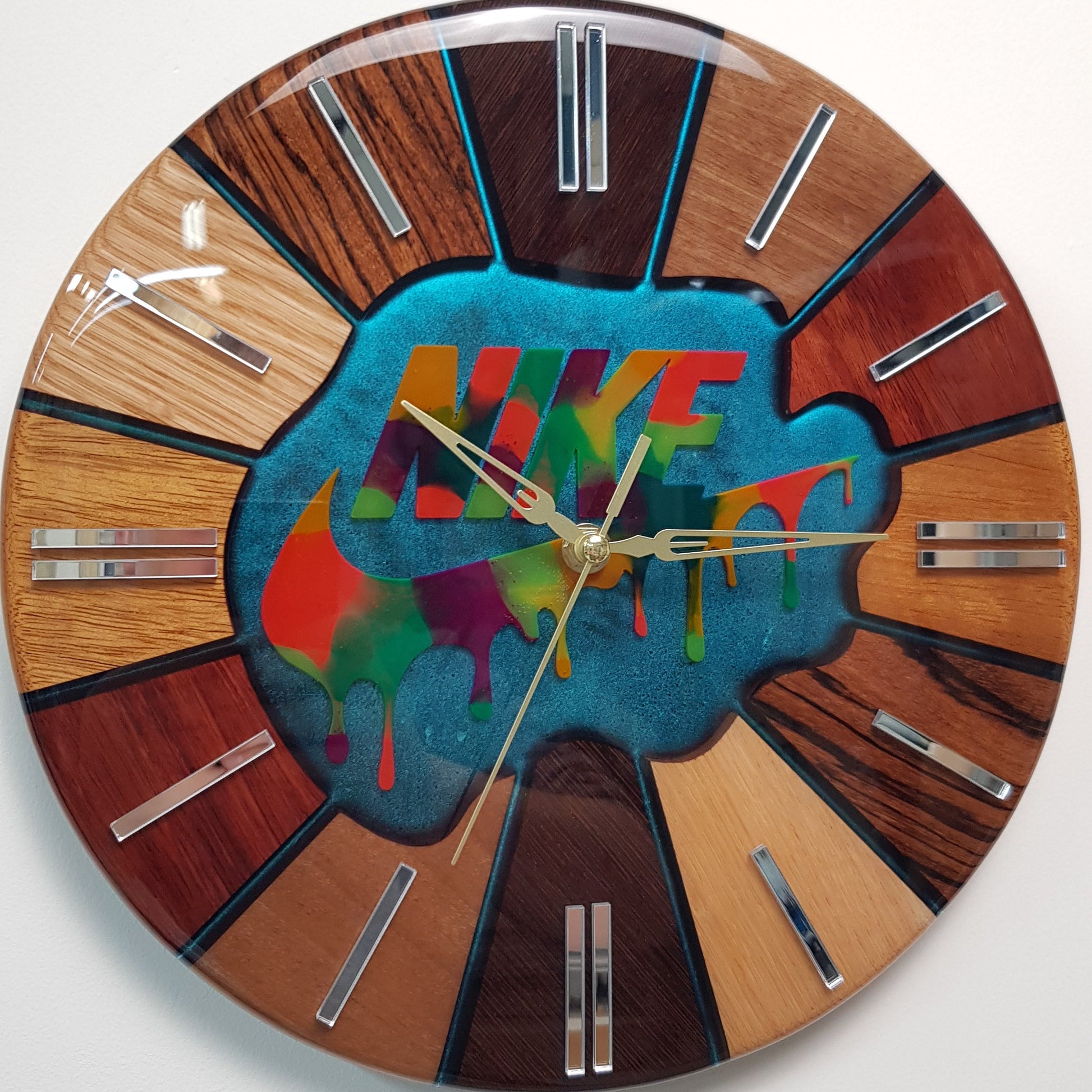 Front view of the “Luxury Chaos – Color Strike” 30 cm art clock with kameleon resin background, colorful dripping effect and wooden segment frame.