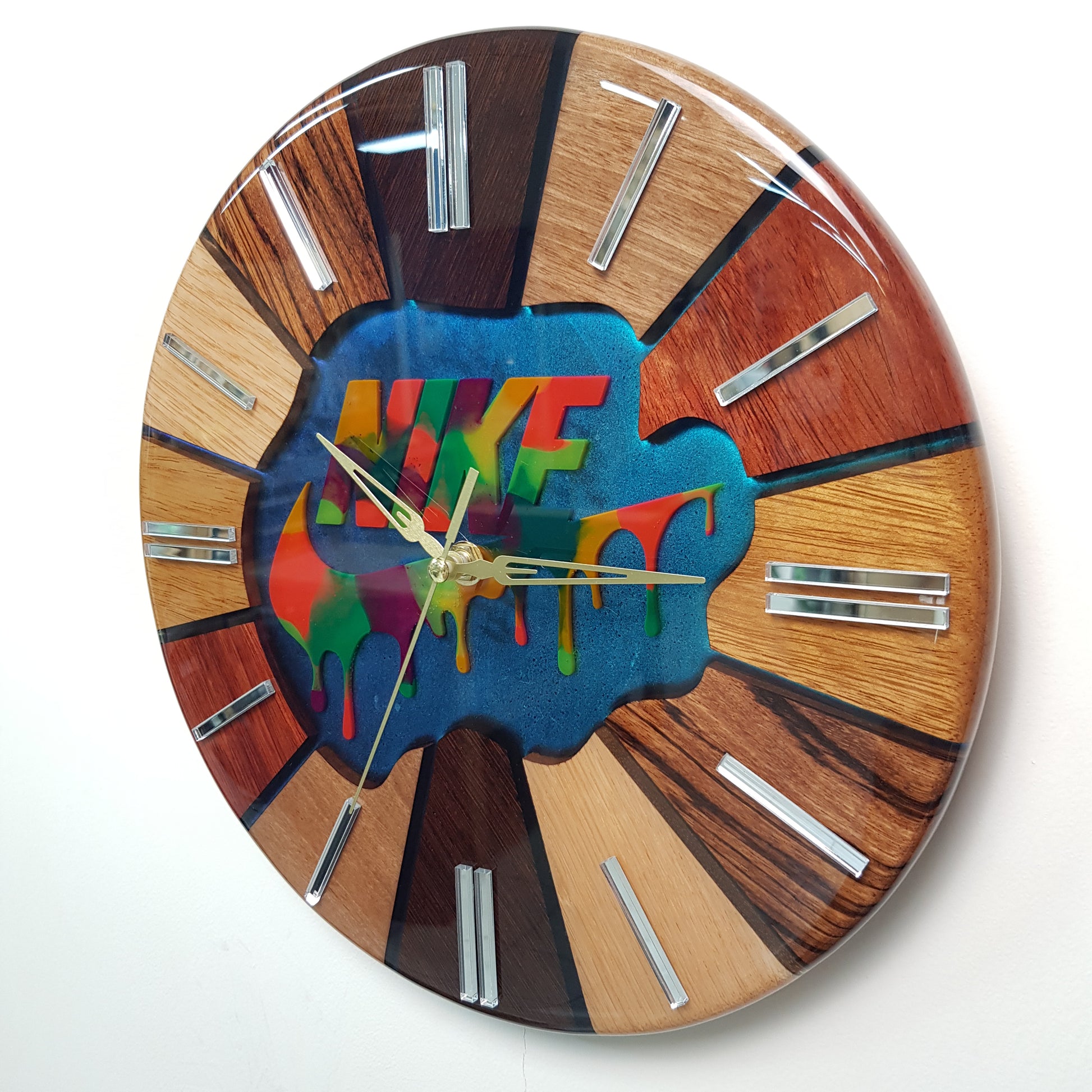 Left-side angle showing the layered resin finish, wooden segments and mirror plexiglass hour markers.