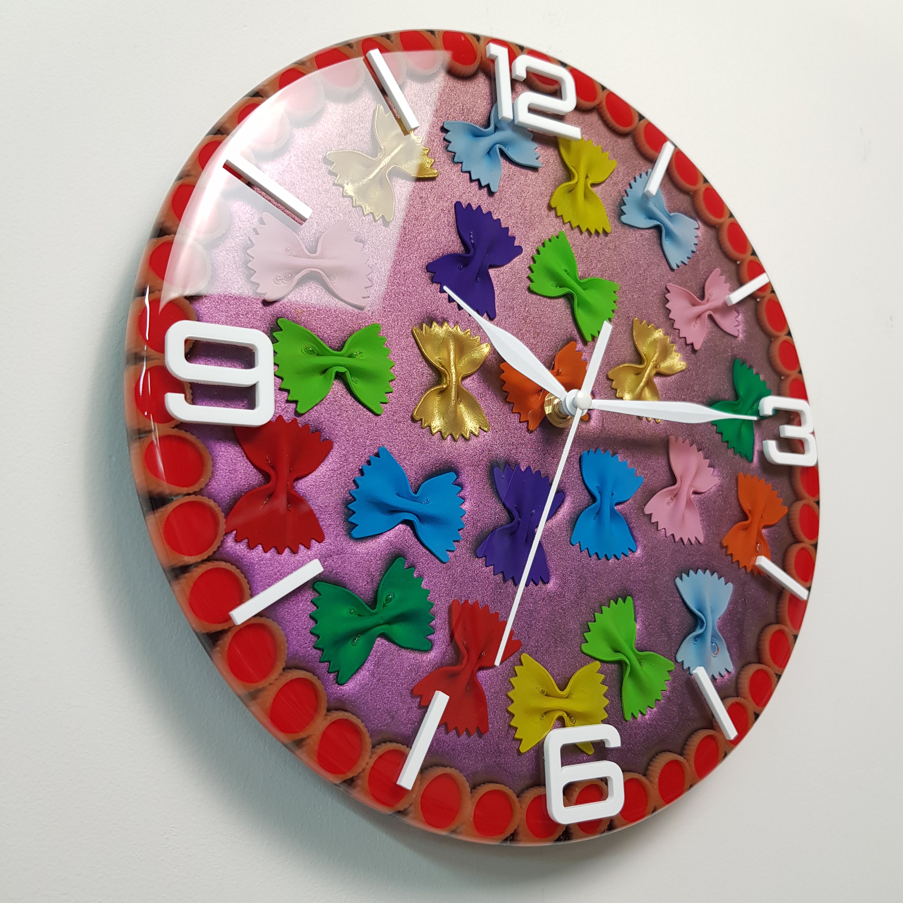 Modern artistic wall clock made with colorful pasta pieces embedded in glossy resin