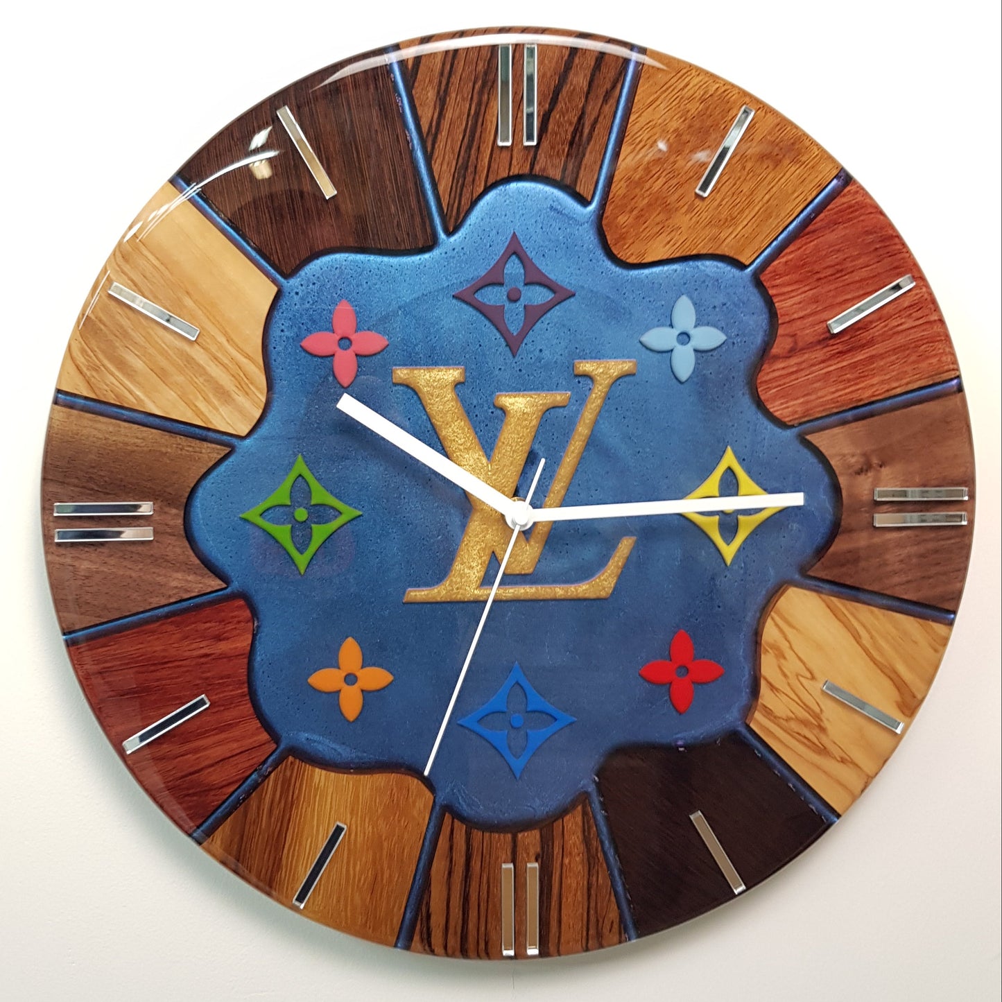 Front view of the “Noble Spectrum” wall clock showing the colorful central motif and exotic wood ring.