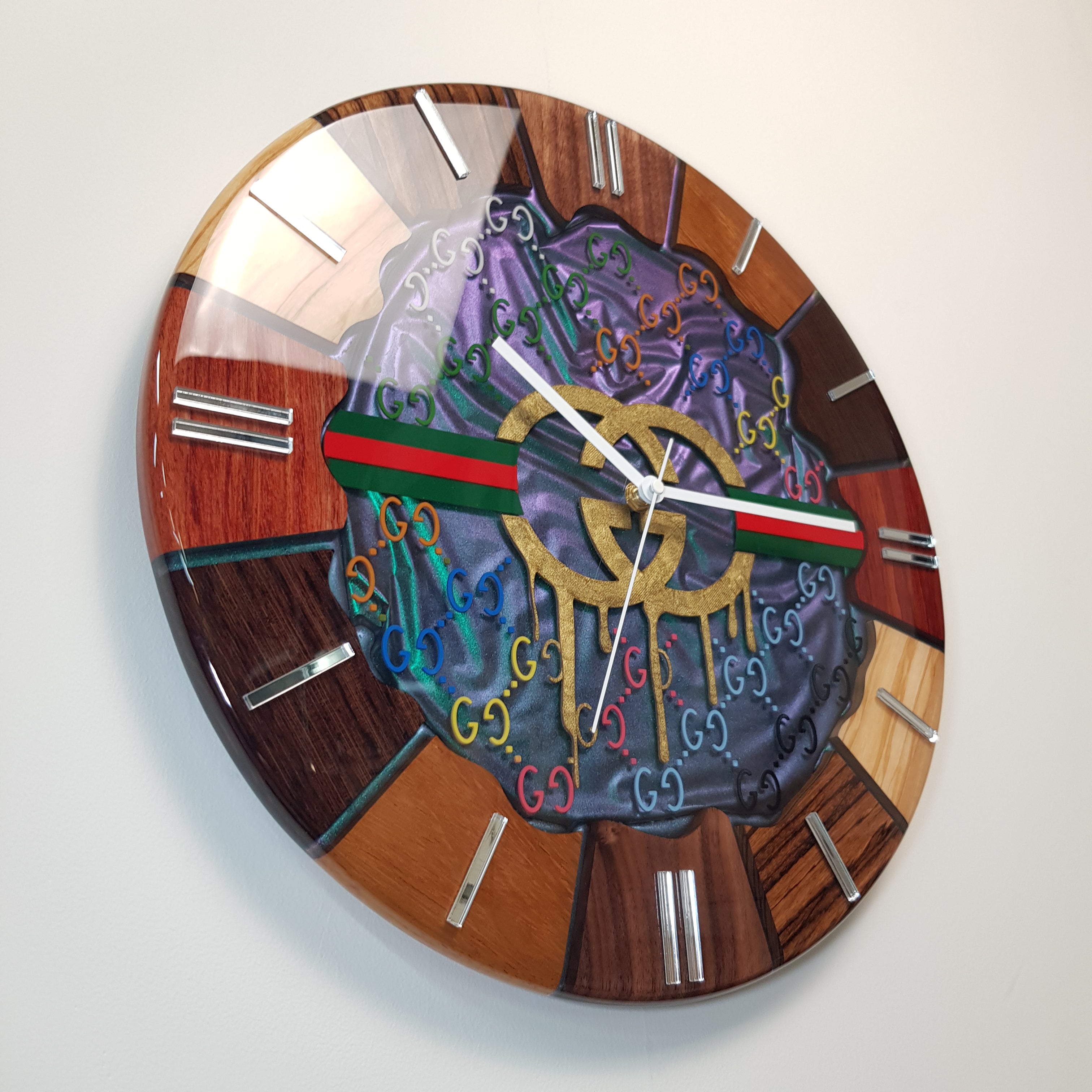 Side angle close-up showing the wood texture, chameleon resin surface and mirrored hour markers of the “Emerald Flow” clock