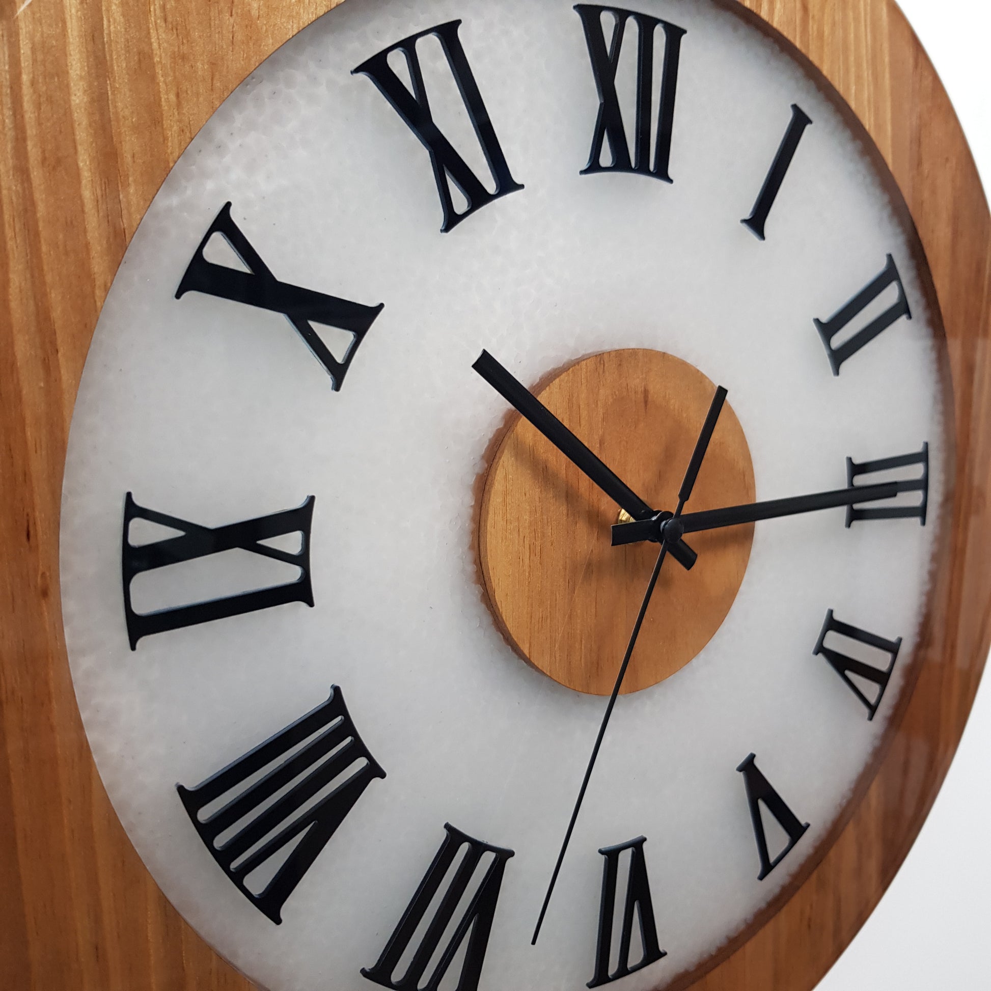 Close-up side view of walnut Roman numeral clock showing glossy epoxy surface.