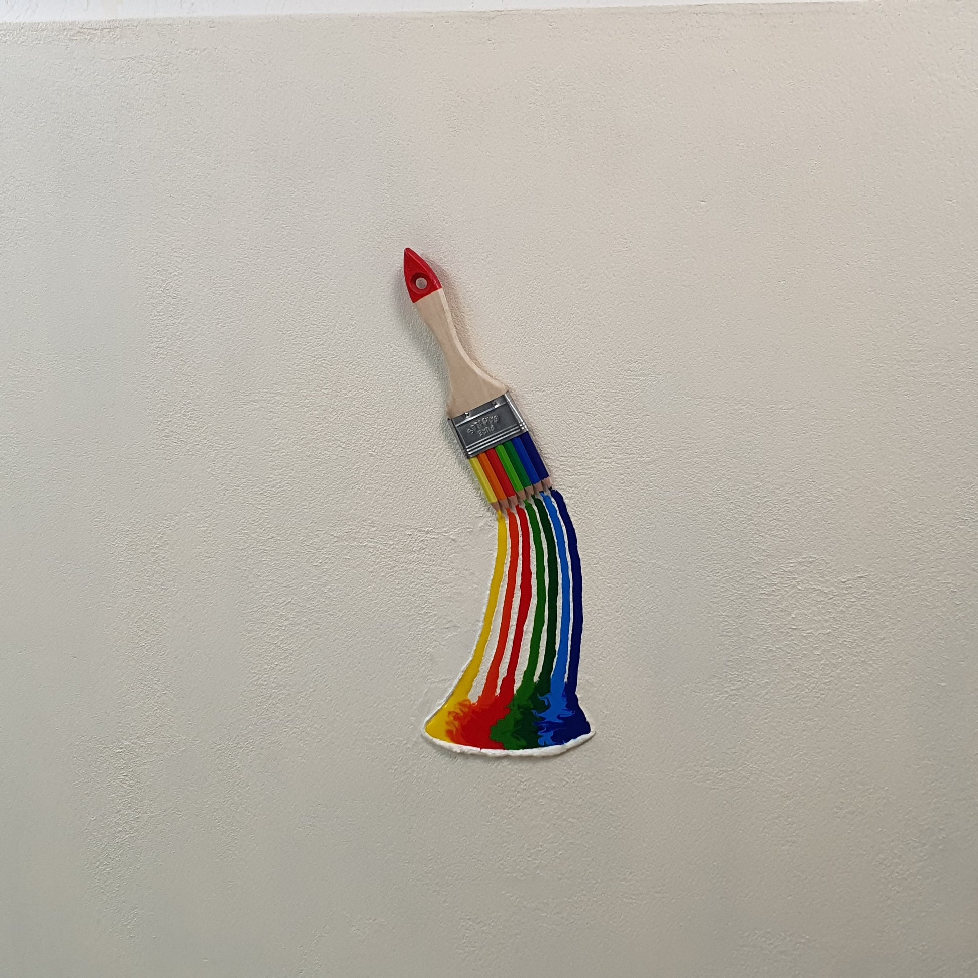 La Forza del Colore conceptual artwork – paintbrush transformed into rainbow of colored pencils, front view