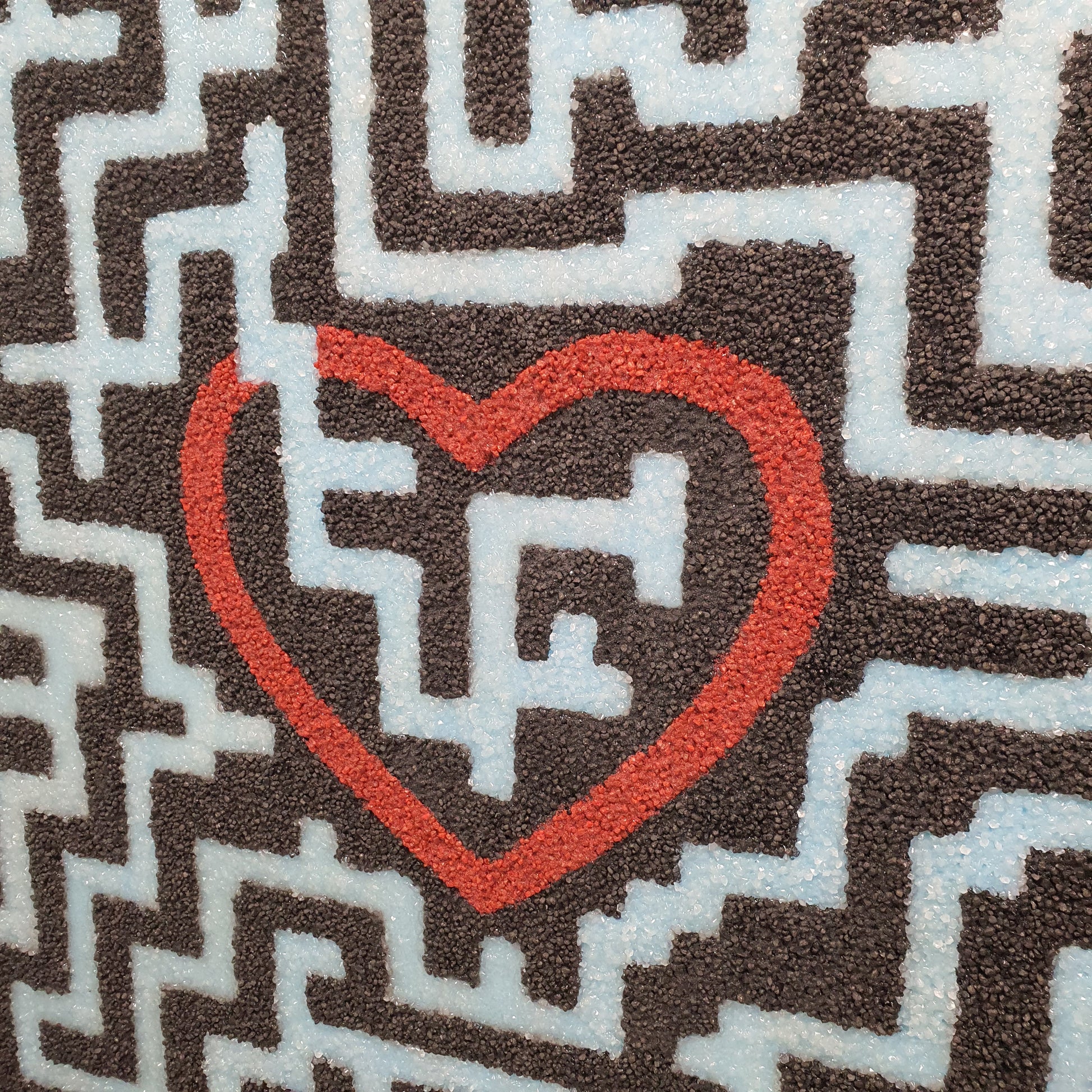 Trovami resin and quartz stone artwork – close-up of glowing labyrinth lines leading to red heart