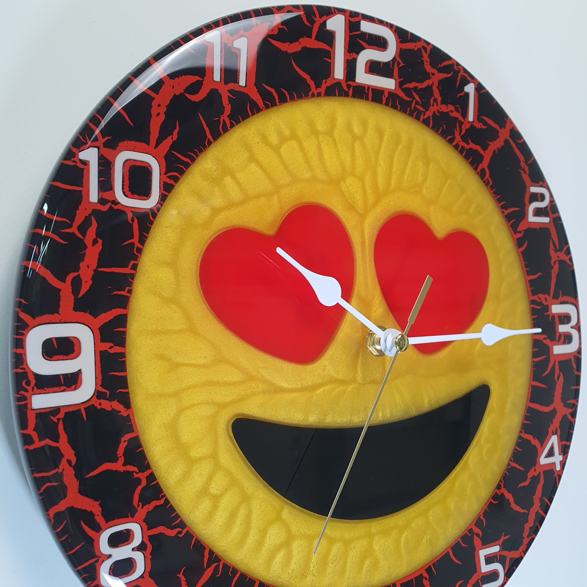 Detail shot showing glossy epoxy texture and heart-shaped eyes on Cuore Rosso clock