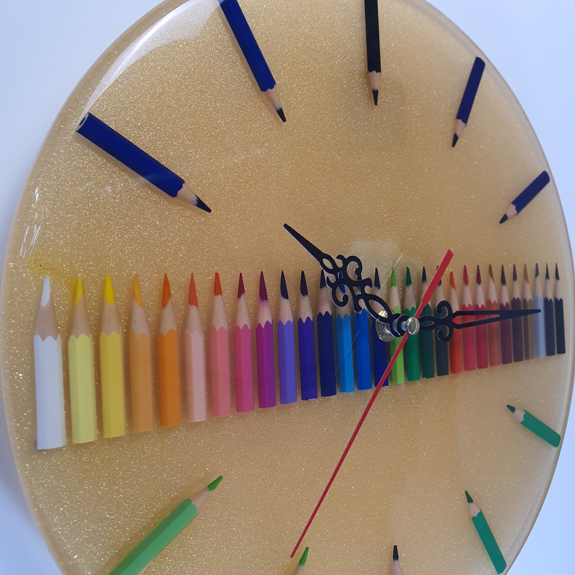 Close-up of handmade resin wall clock with embedded colored pencils