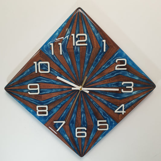 Front view of the “Walnut Wave” wall clock – handcrafted from walnut wood and blue epoxy, geometric sunburst pattern