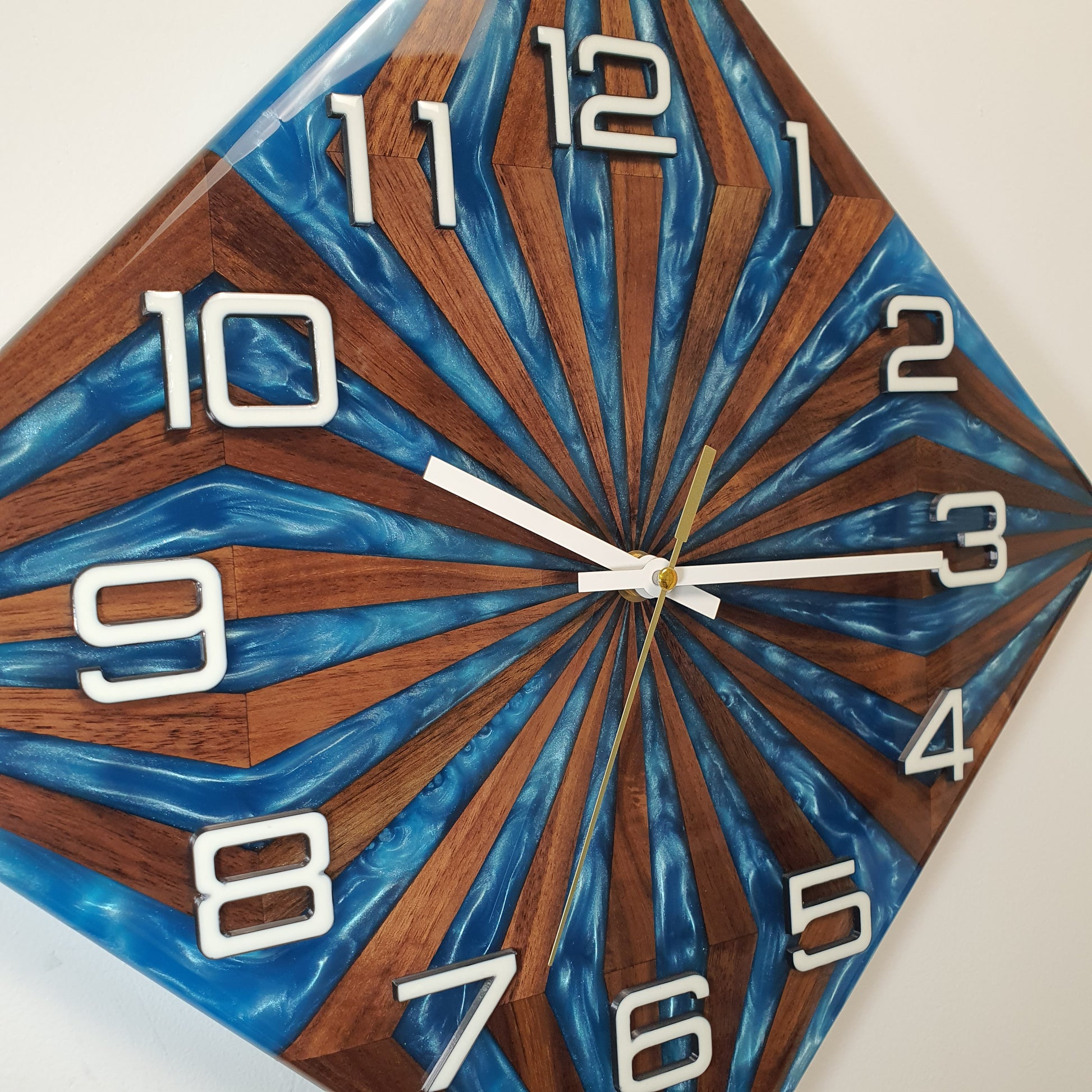 Close-up detail of the Walnut Wave clock showing rich walnut grain and pearl-effect epoxy in dynamic rays