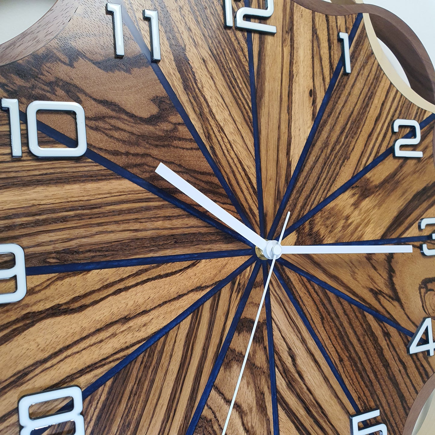Close-up of the Crown Circle clock face – detailed wood grain, white numbers, and deep blue resin accents.