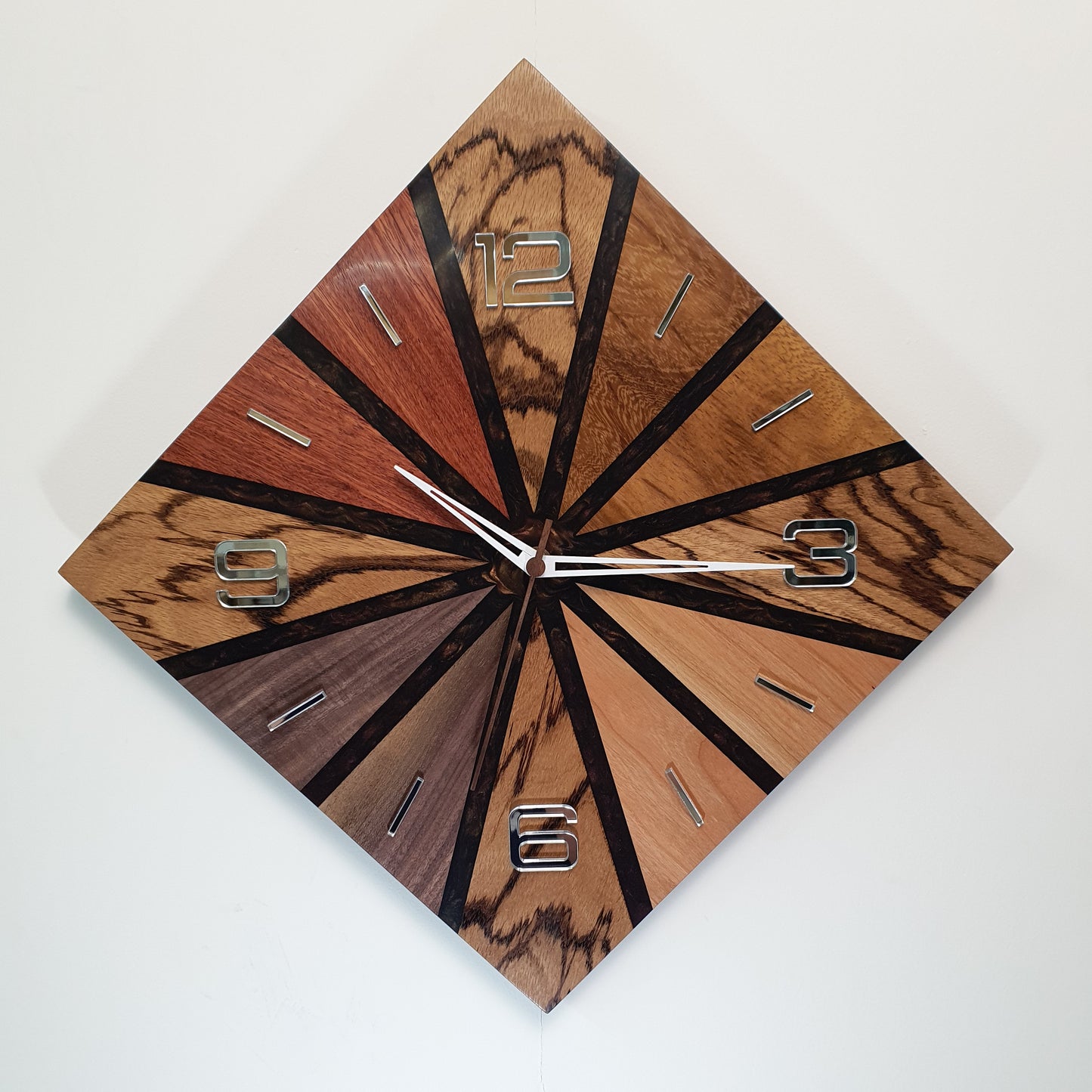 Front view of the “Wood Line – Natural Pulse” wall clock showing its radial wood pattern and mirrored numbers