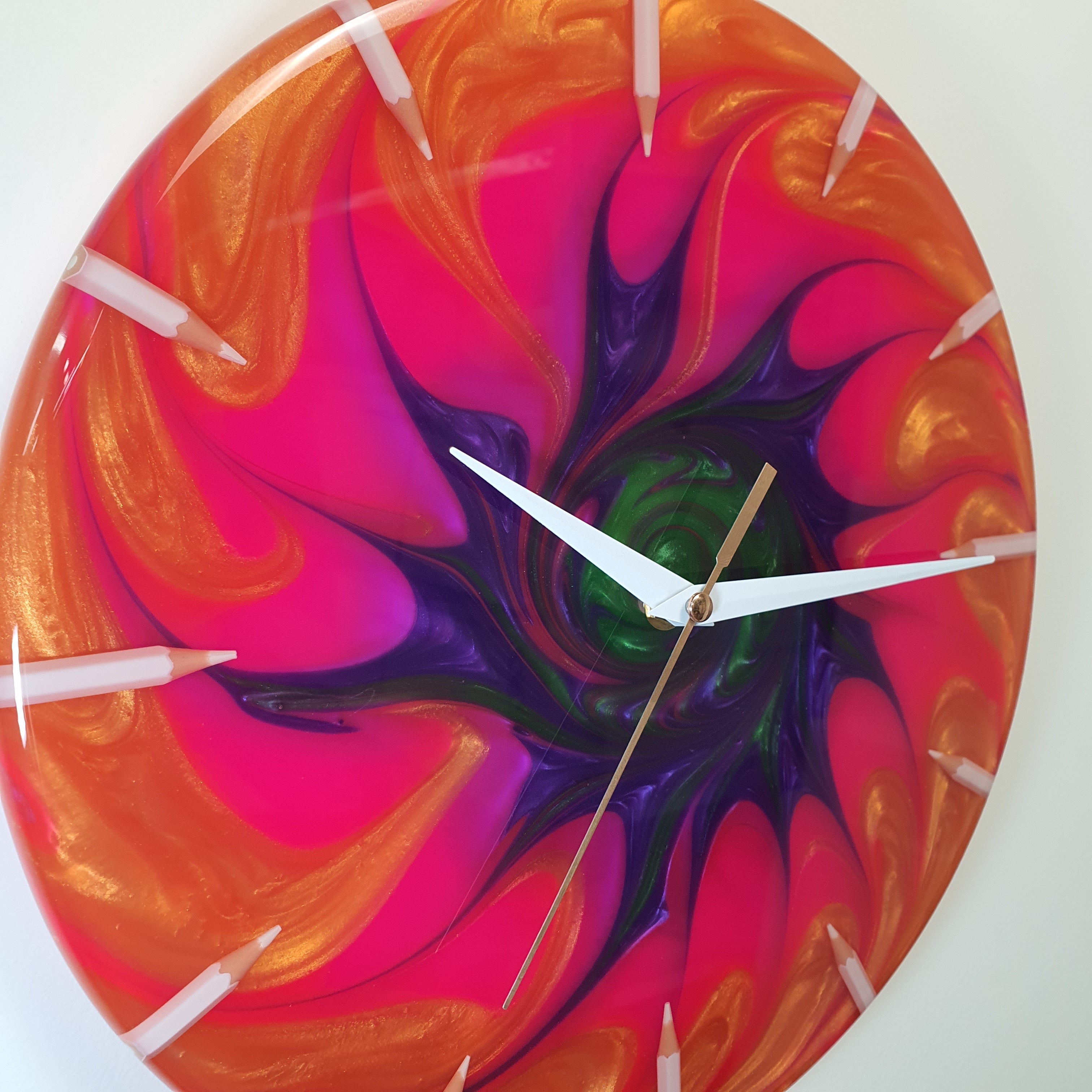 Close-up of the epoxy resin surface with fuchsia, orange, green, and violet colors blending together