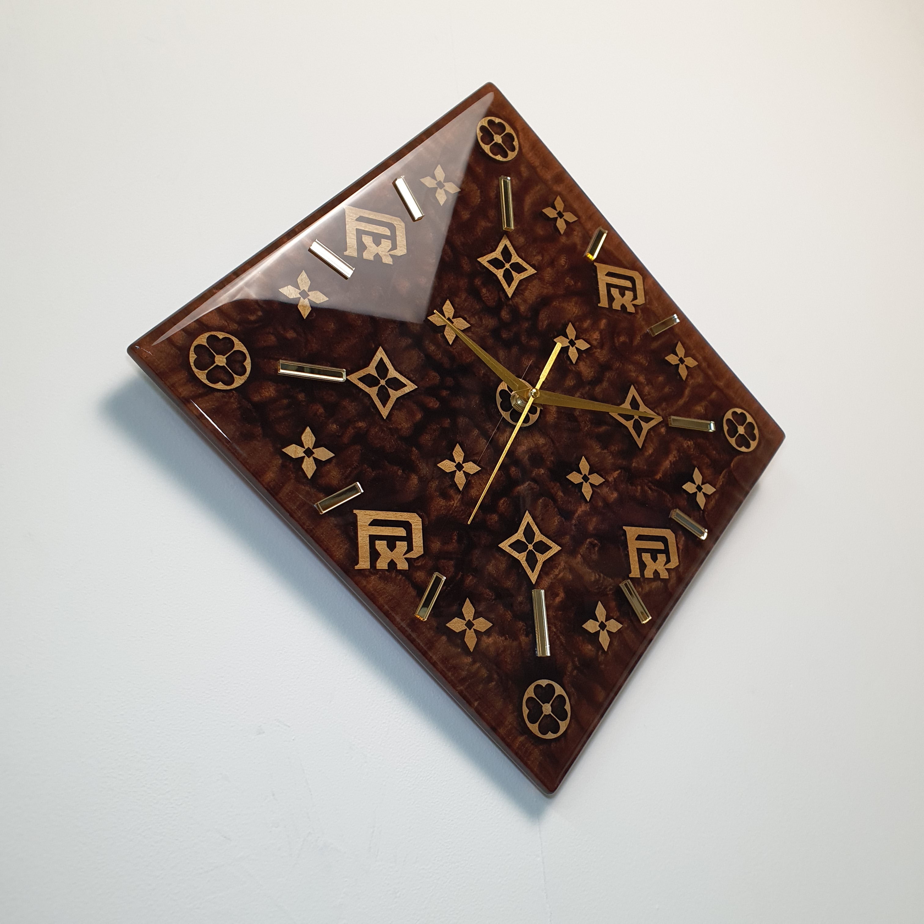 Left side view showing the glossy brown resin surface with a leather-like texture and wooden inlays of the FxPattern No.1 clock.