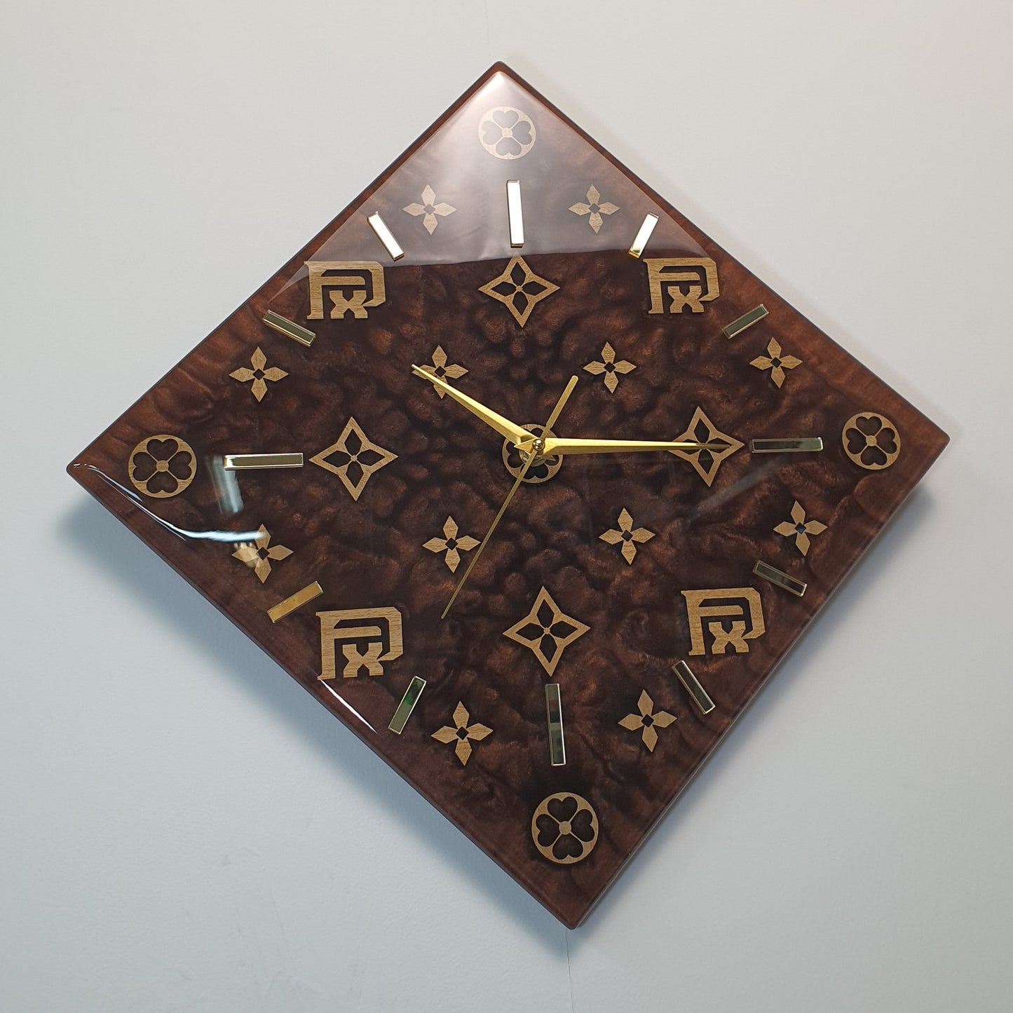 Top-corner angled shot of FxPattern No.1 emphasizing its reflective resin finish and harmonious golden details.