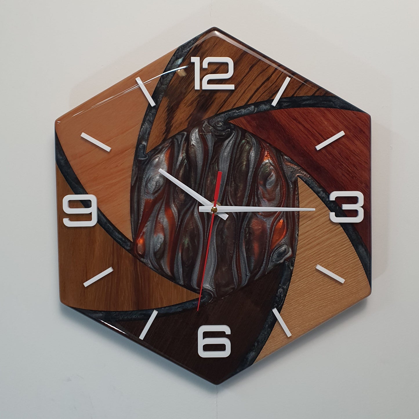 Front view of the “Fusion Hexa” wall clock showing its hexagonal shape and wooden segments combined with resin