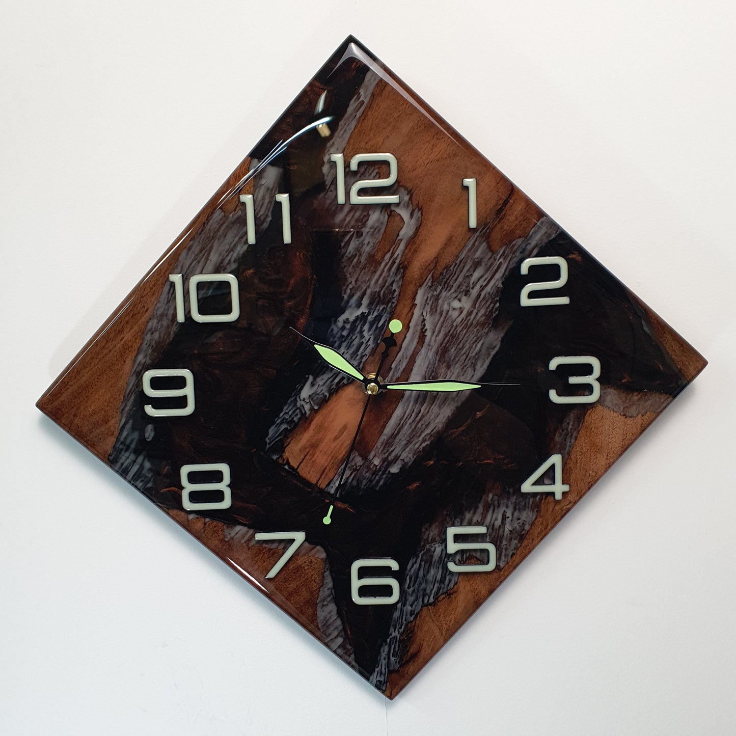 Front view of the handmade walnut wall clock filled with fluorescent resin, showing the natural wood texture and luminous details.