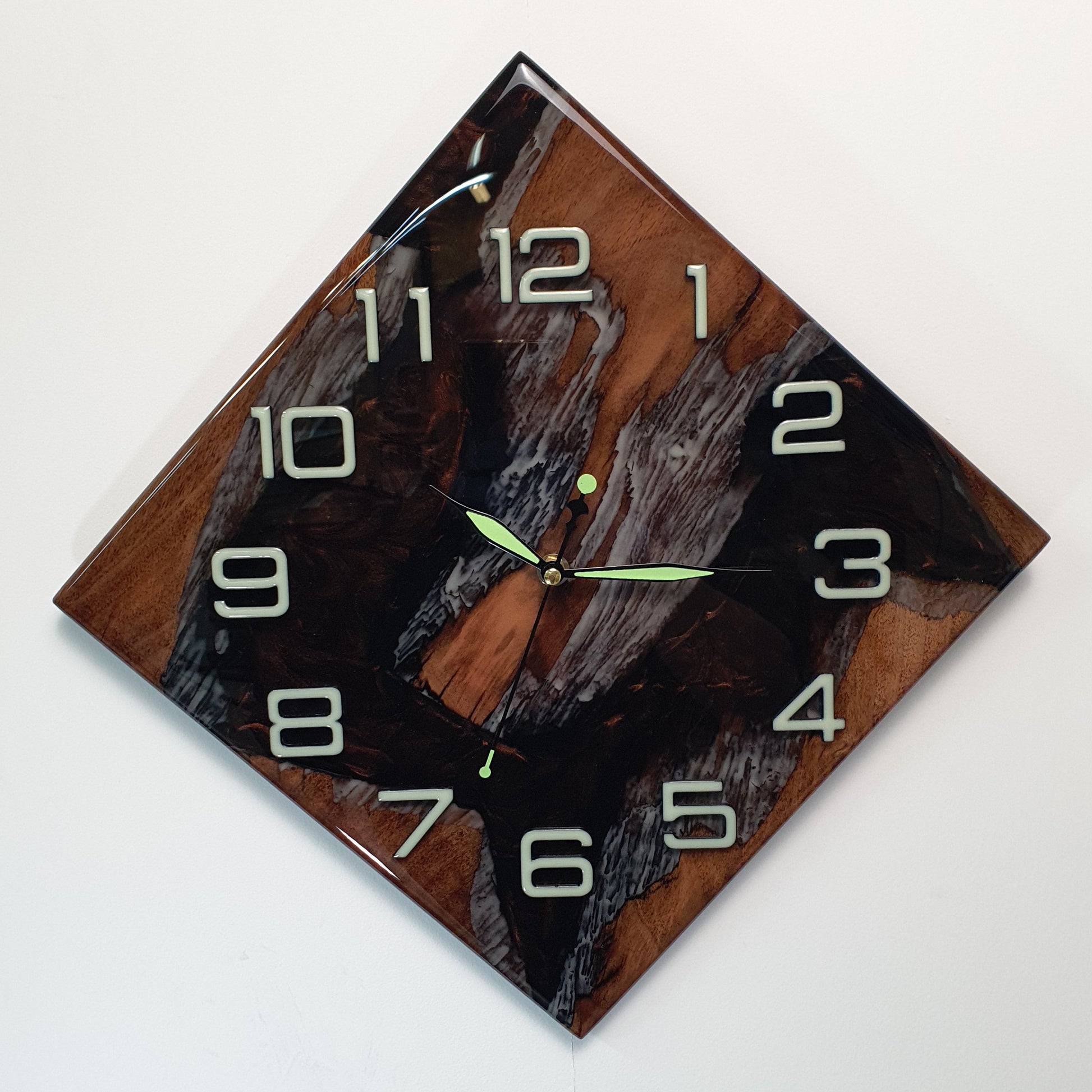 Front view of the handmade walnut wall clock filled with fluorescent resin, showing the natural wood texture and luminous details.