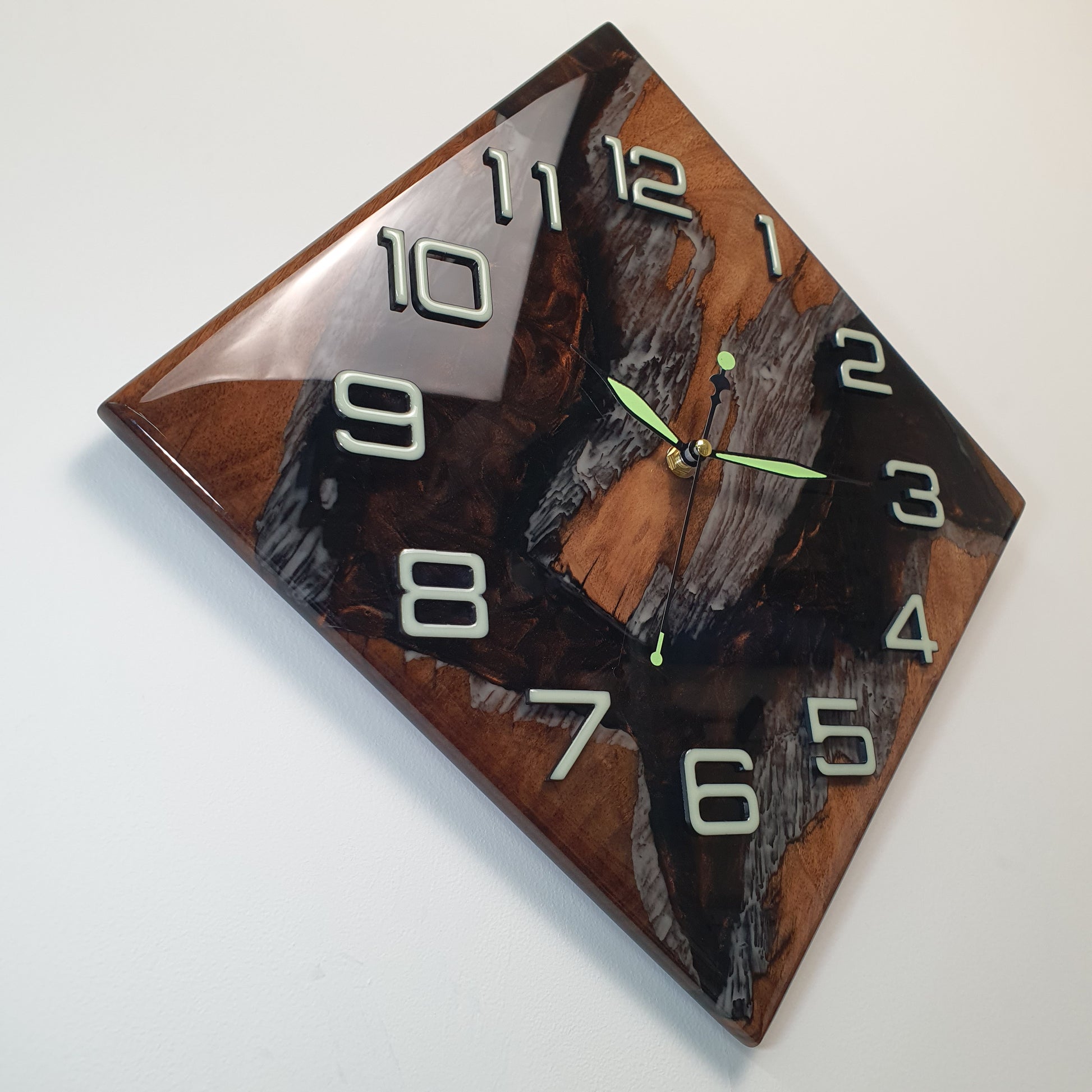 Side view of the walnut and resin wall clock highlighting the depth of texture and elegant luminous elements.