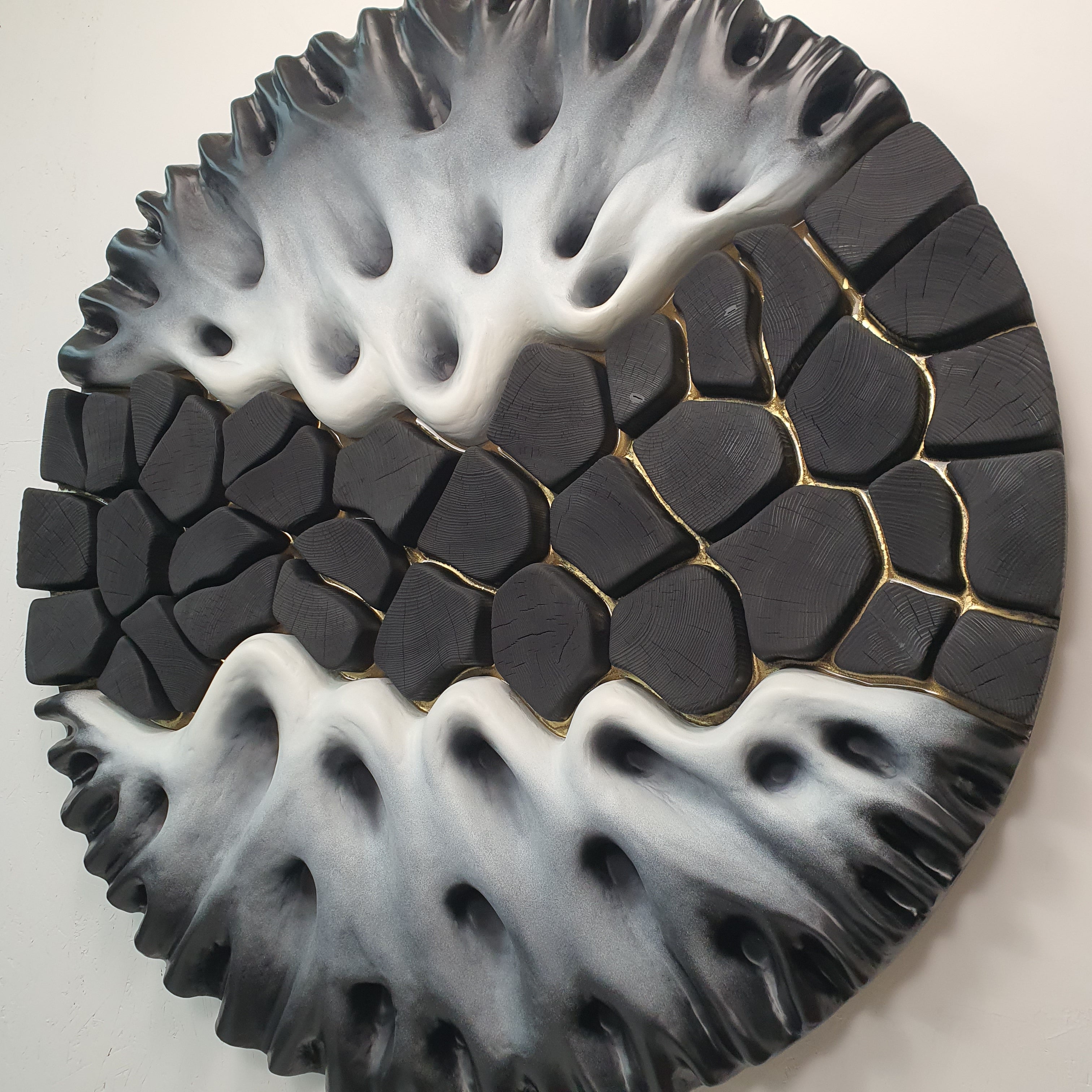 Angled perspective of modern relief sculpture highlighting depth and texture