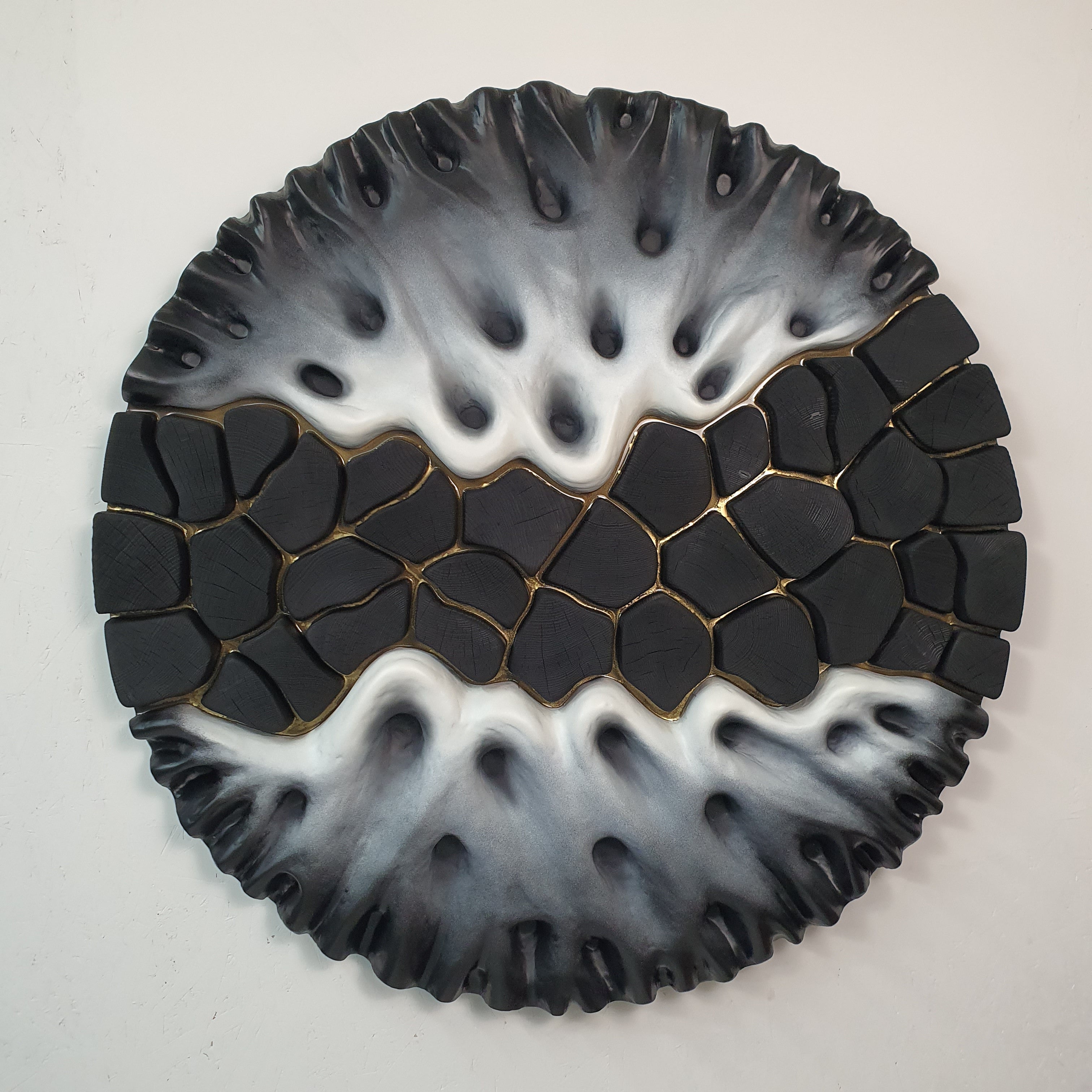 Front view of Equilibrio Spezzato modern circular wall sculpture with gold accents
