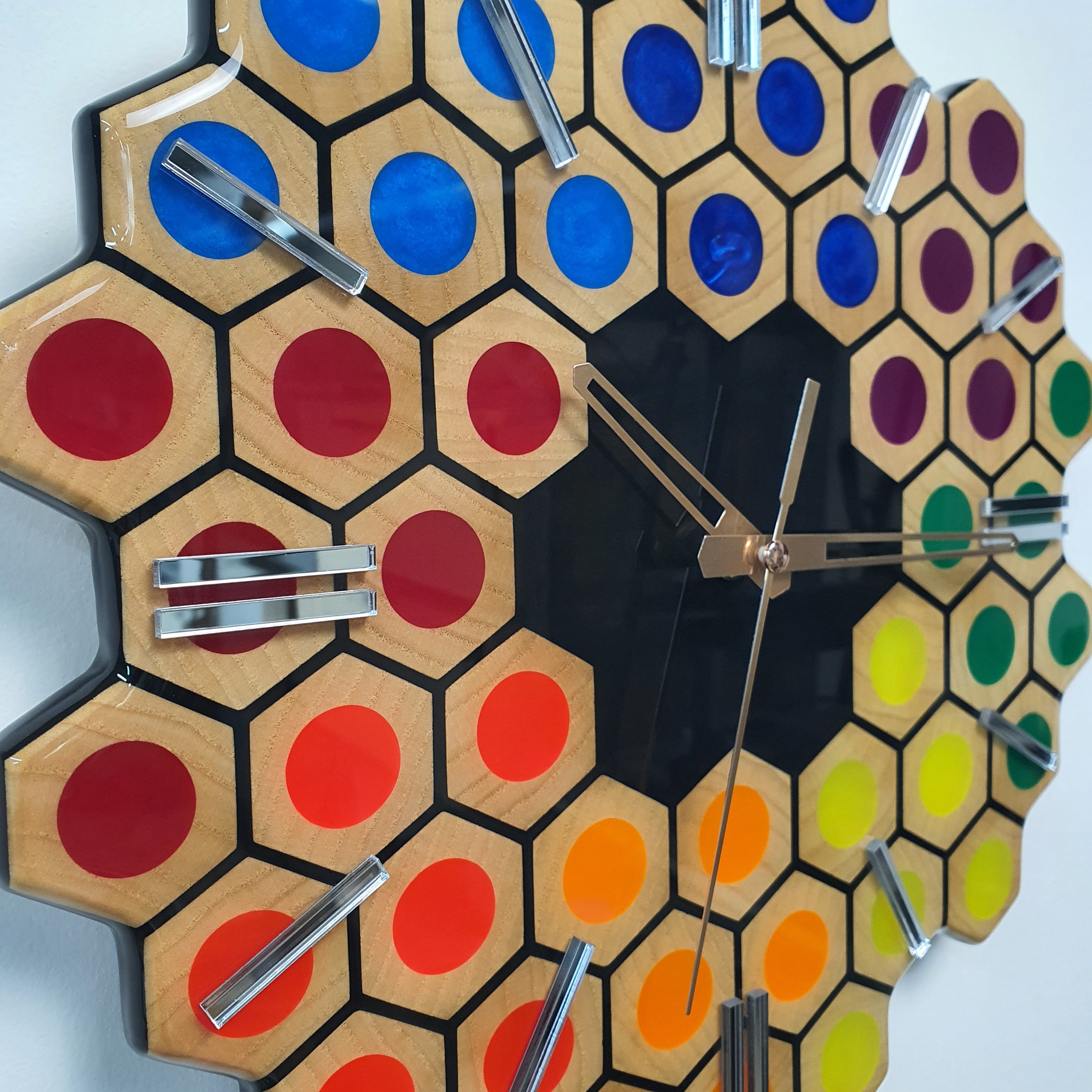 Close-up of Spectrum Hive ash wood clock with colorful epoxy resin hexagon pattern