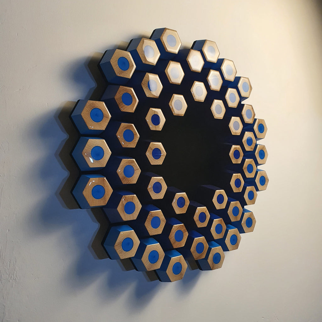 Modern minimalist relief artwork with blue geometric modules and light absorbing black void