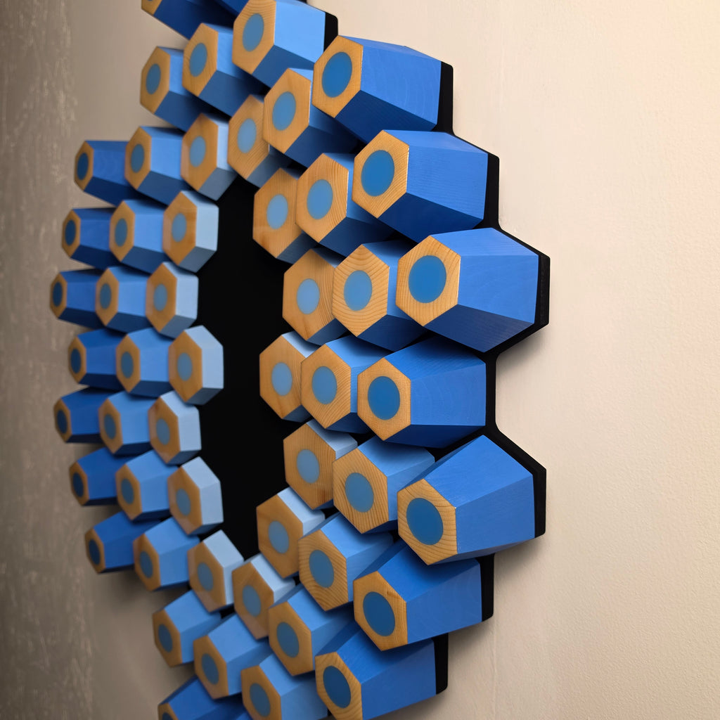 Abstract blue wall relief with tilted geometric modules creating dynamic shadows and visual motion