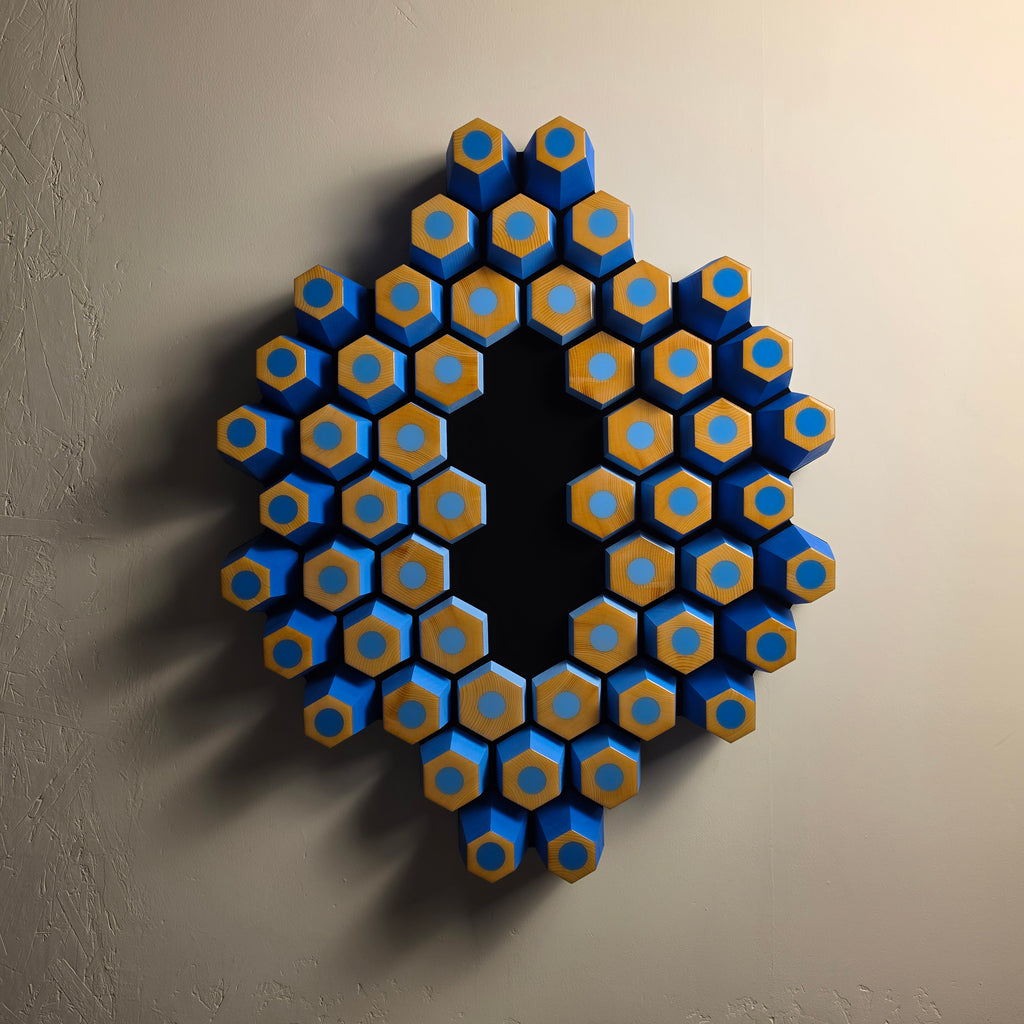Orbita wall sculpture from the Profondità series featuring blue geometric forms and a light-absorbing black center
