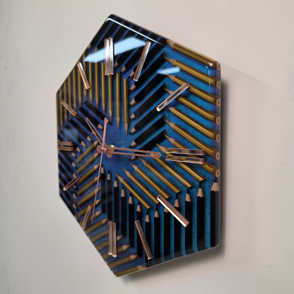 Modern resin wall clock featuring black and gold colored pencils in a hexagonal pattern