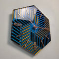 Geometry of Color wall clock made from black and gold colored pencils on a blue-violet chameleon background