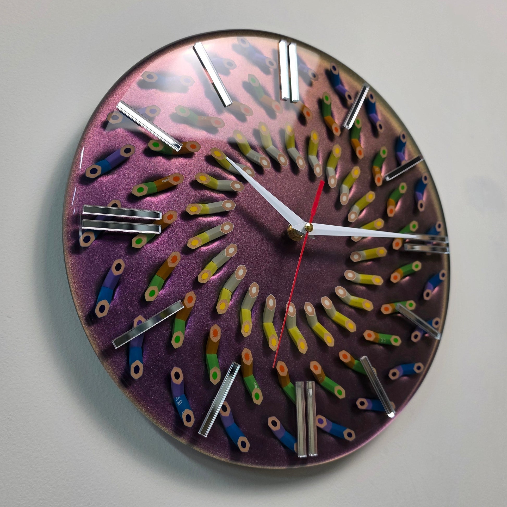 Drawn Into Color wall clock with colored pencils arranged in a spiral pattern