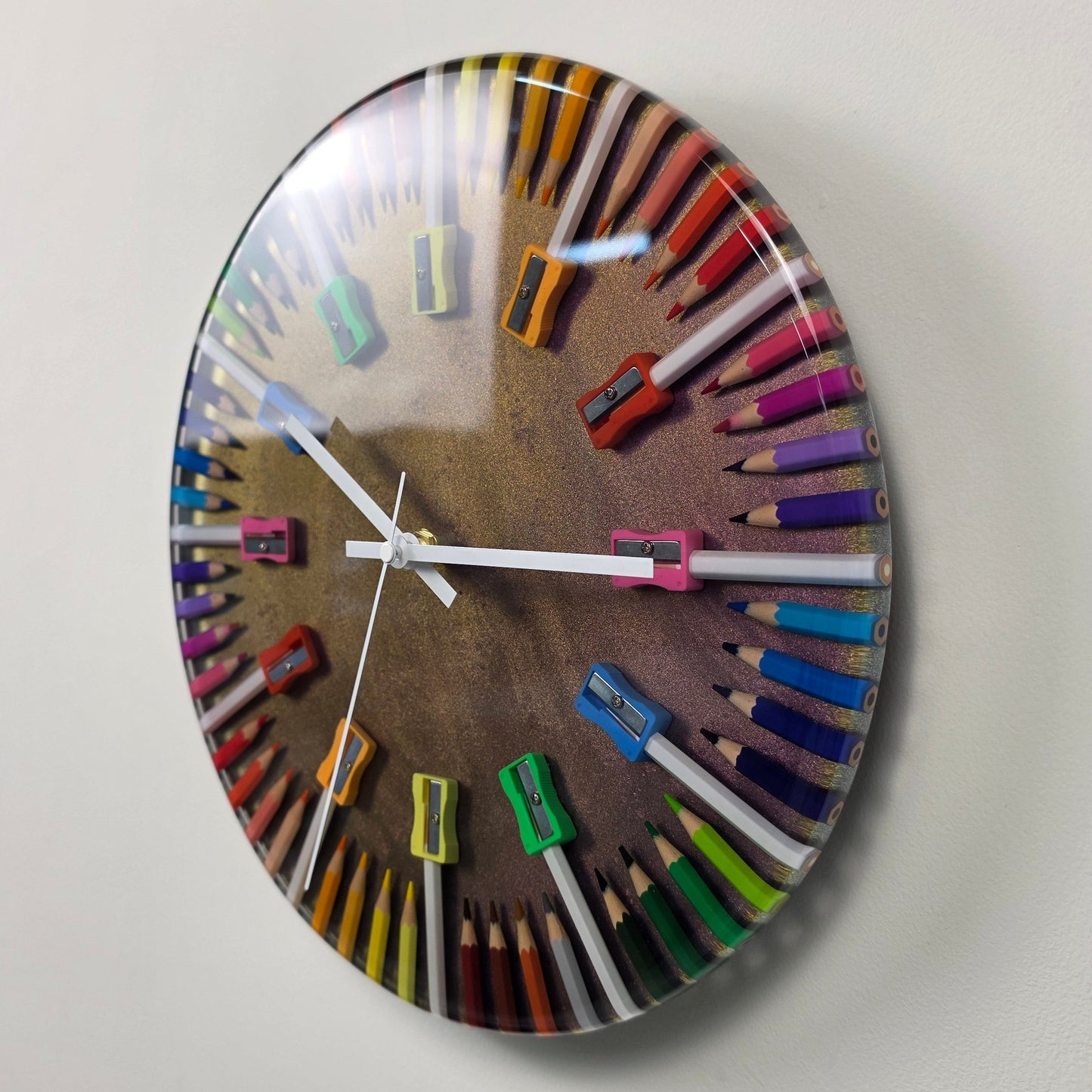 Modern wall clock featuring colorful pencil shavings and white plexiglass markers