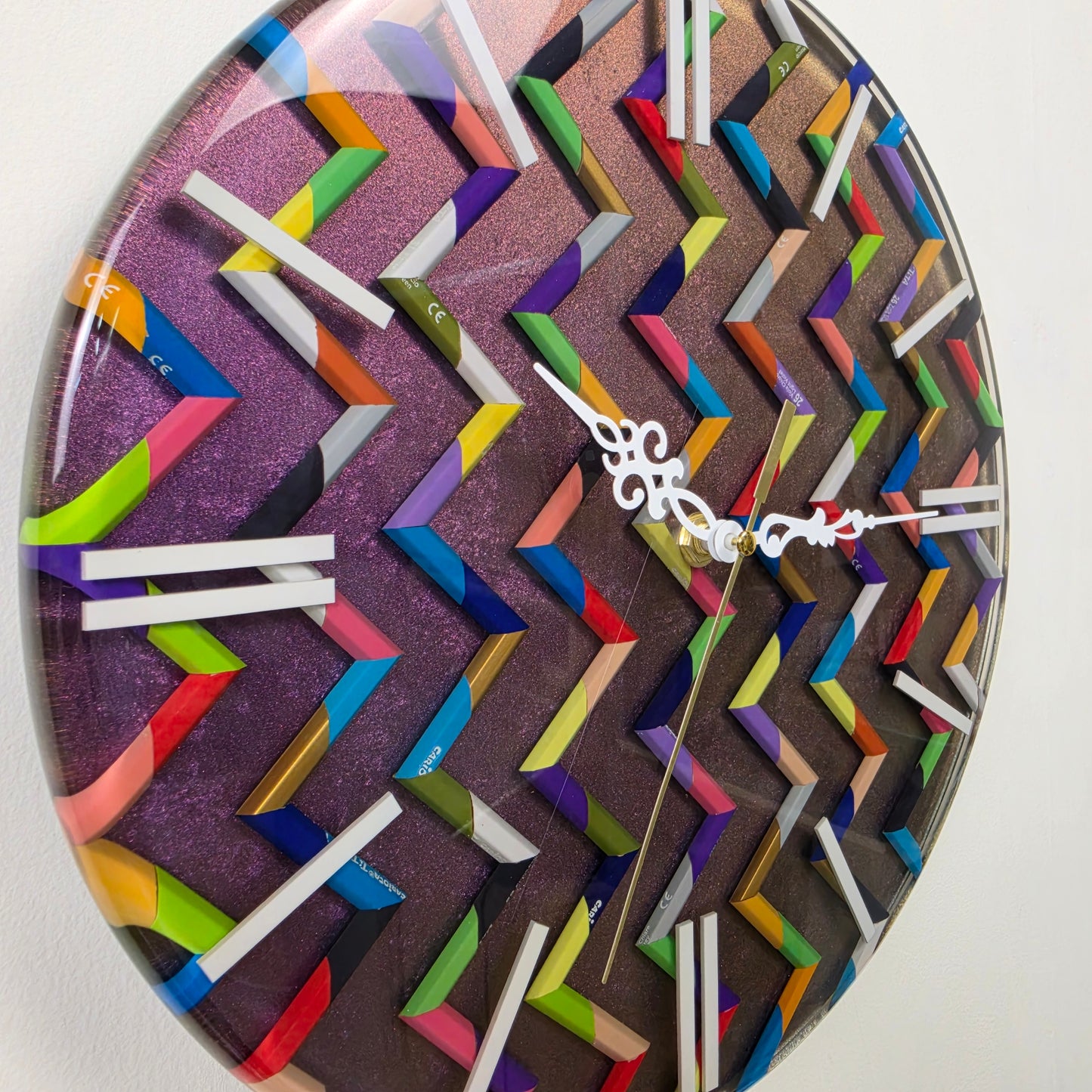 Unique colored pencil wall clock featuring a vibrant geometric design, metallic background and handcrafted resin finish.