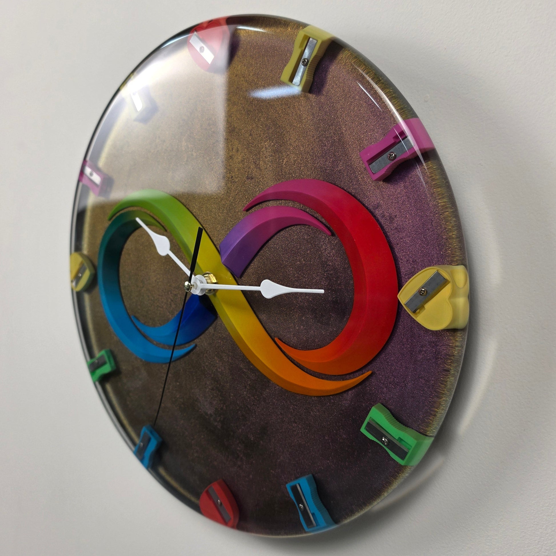 Unique functional art wall clock featuring rainbow infinity symbol and colorful pencil sharpeners