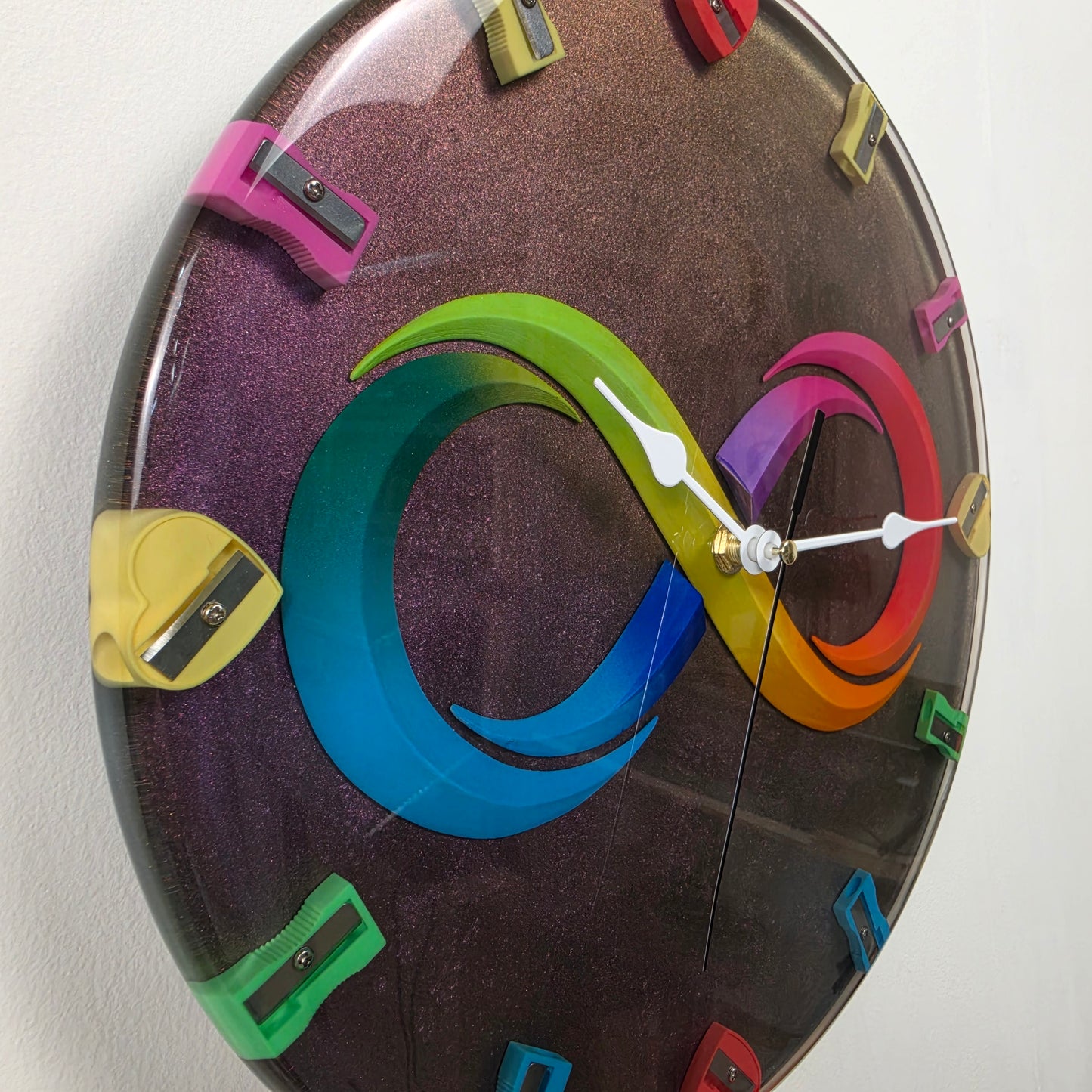Handcrafted wall clock with infinity symbol, colorful pencil sharpeners and premium epoxy resin made in Italy