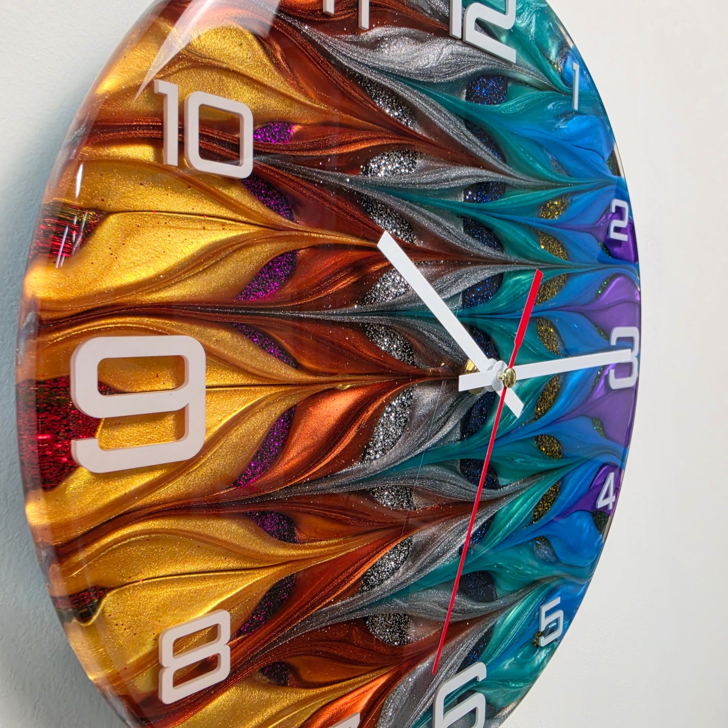 Handcrafted abstract wall clock featuring flowing epoxy resin colors, shimmering pigments and white acrylic numerals