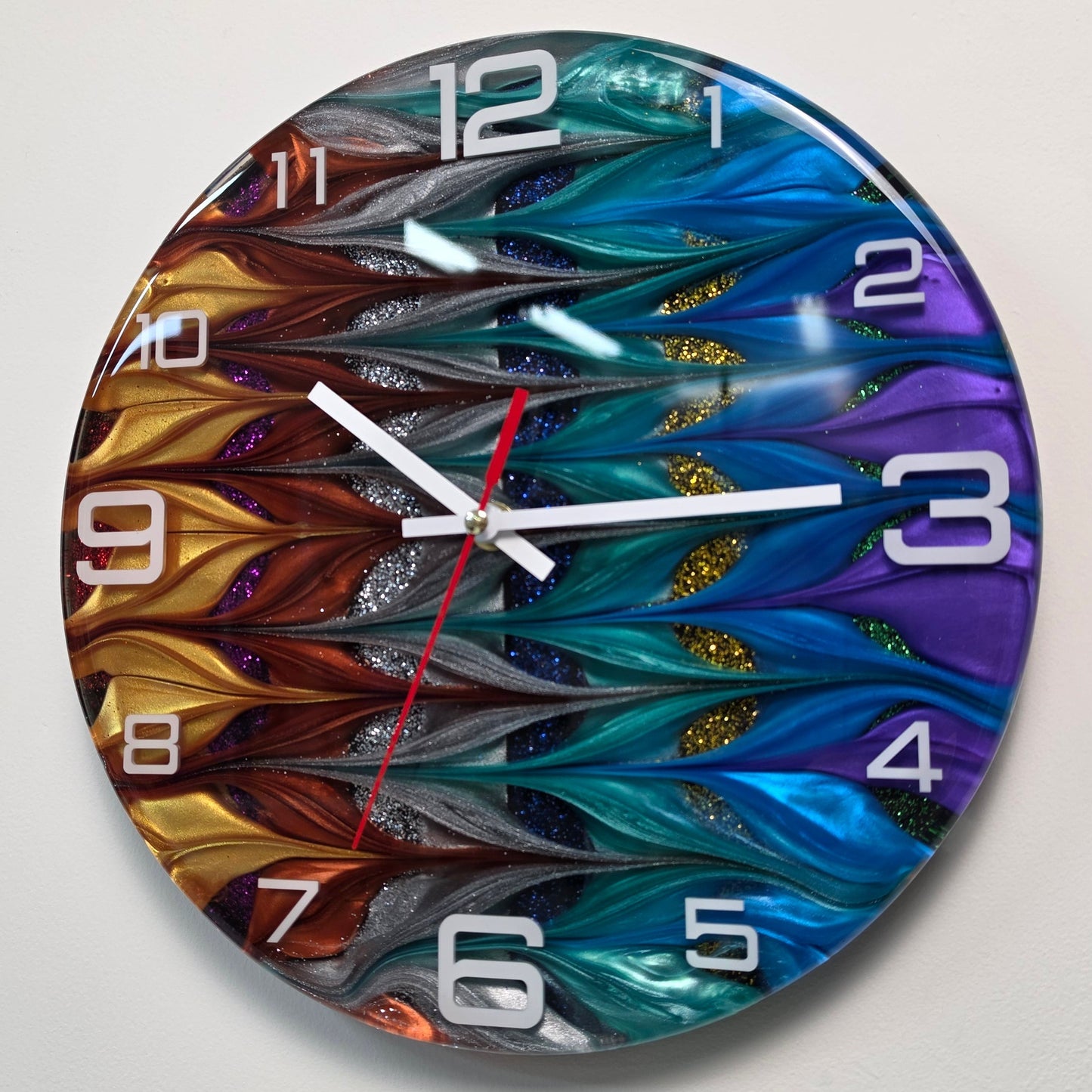 Unique abstract resin wall clock with flowing metallic colors, white acrylic numerals and contemporary design